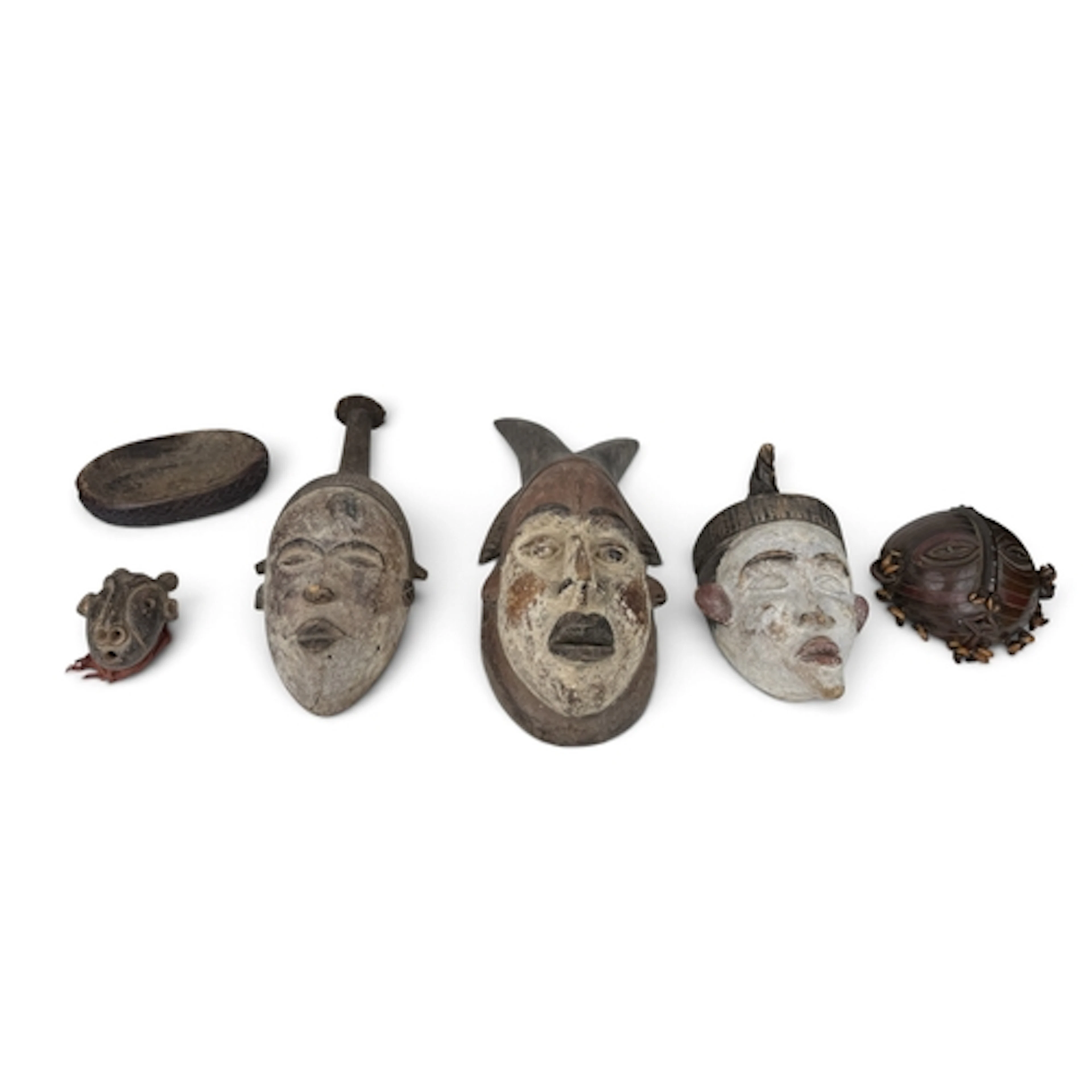 A GROUP OF AFRICAN TRIBAL WOODEN MASKS TOGETHER WITH A CARVE...