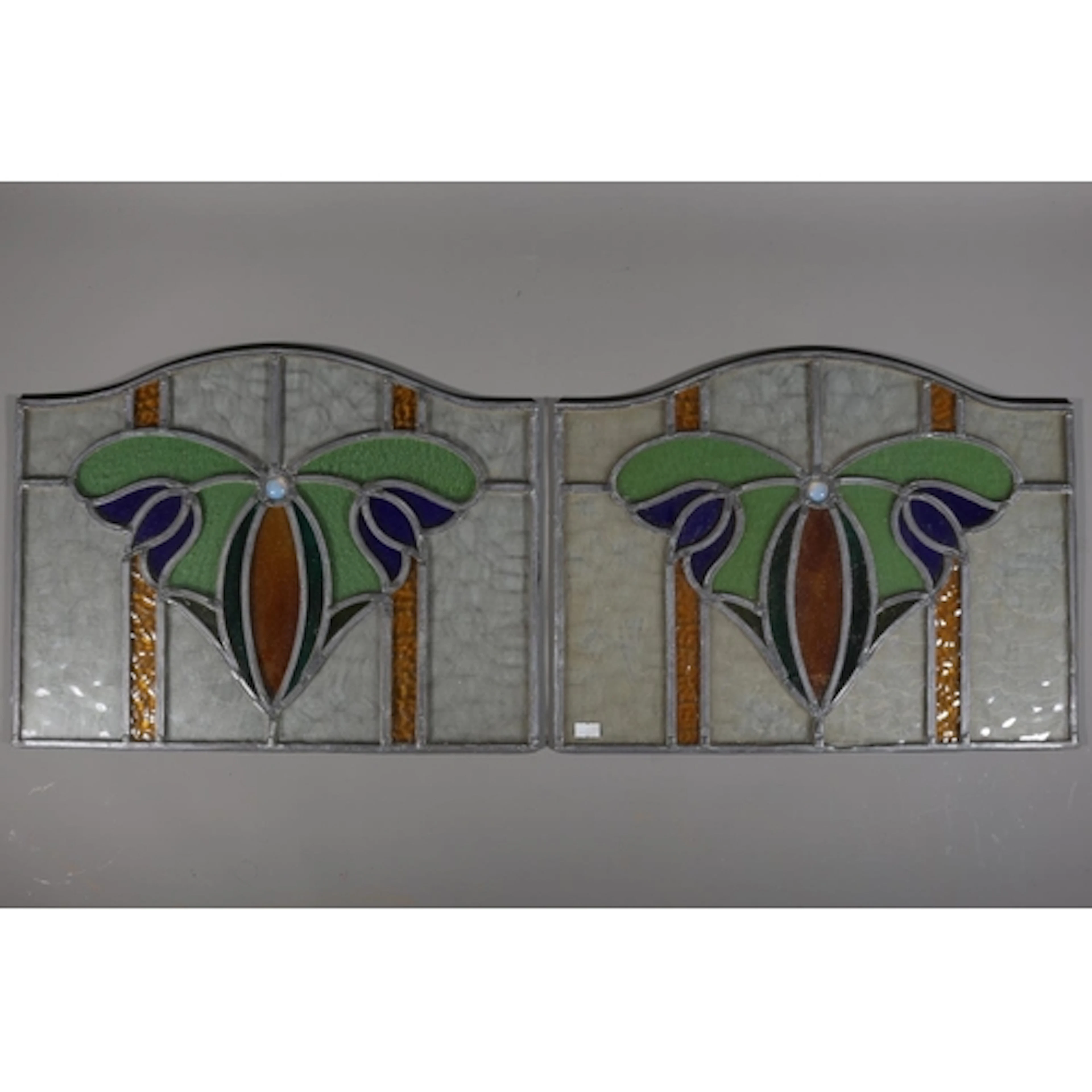 Pair of arched lead lined stained glass windows with bluebel...