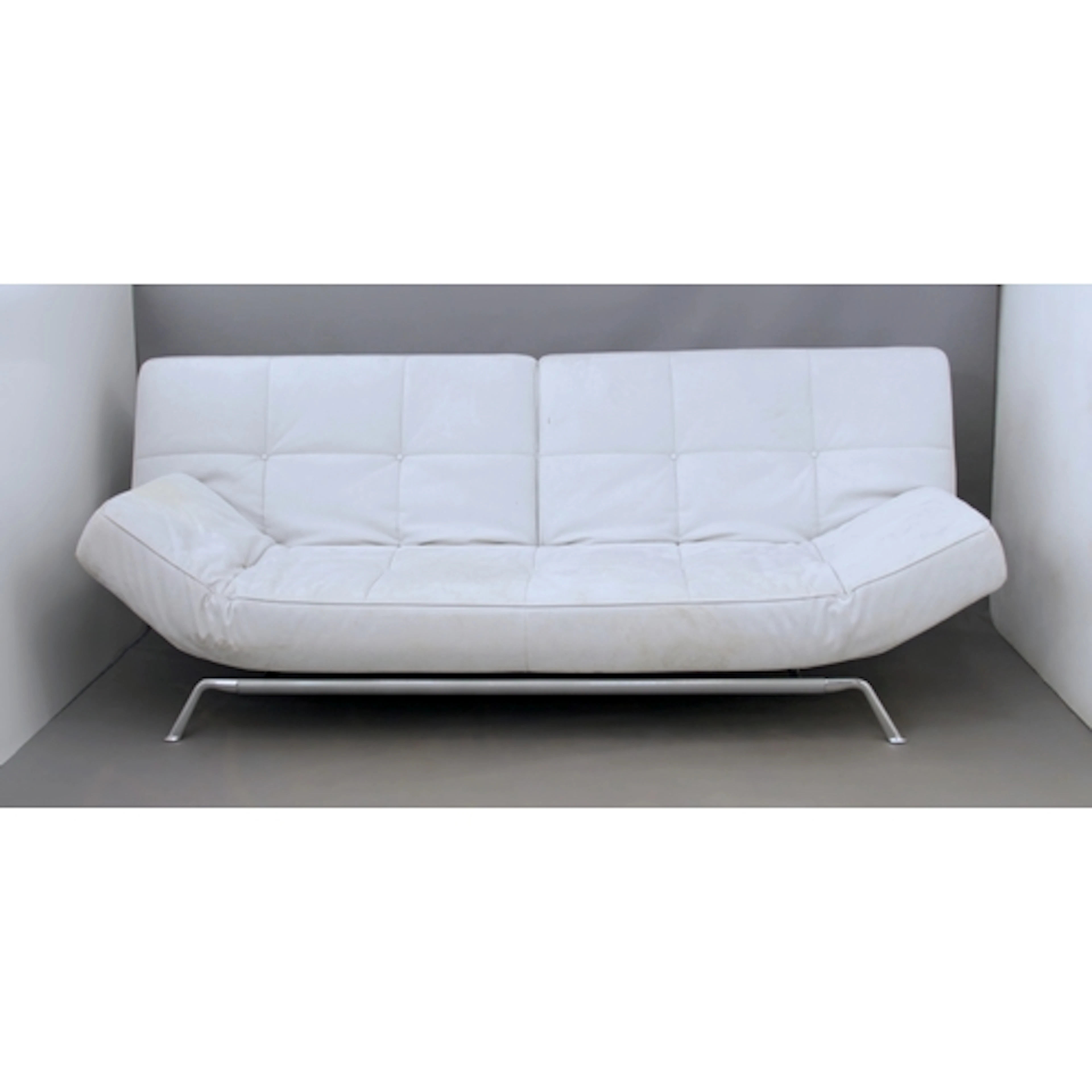 A Ligne Roset sofa bed - upholstered in buttoned pale grey a...