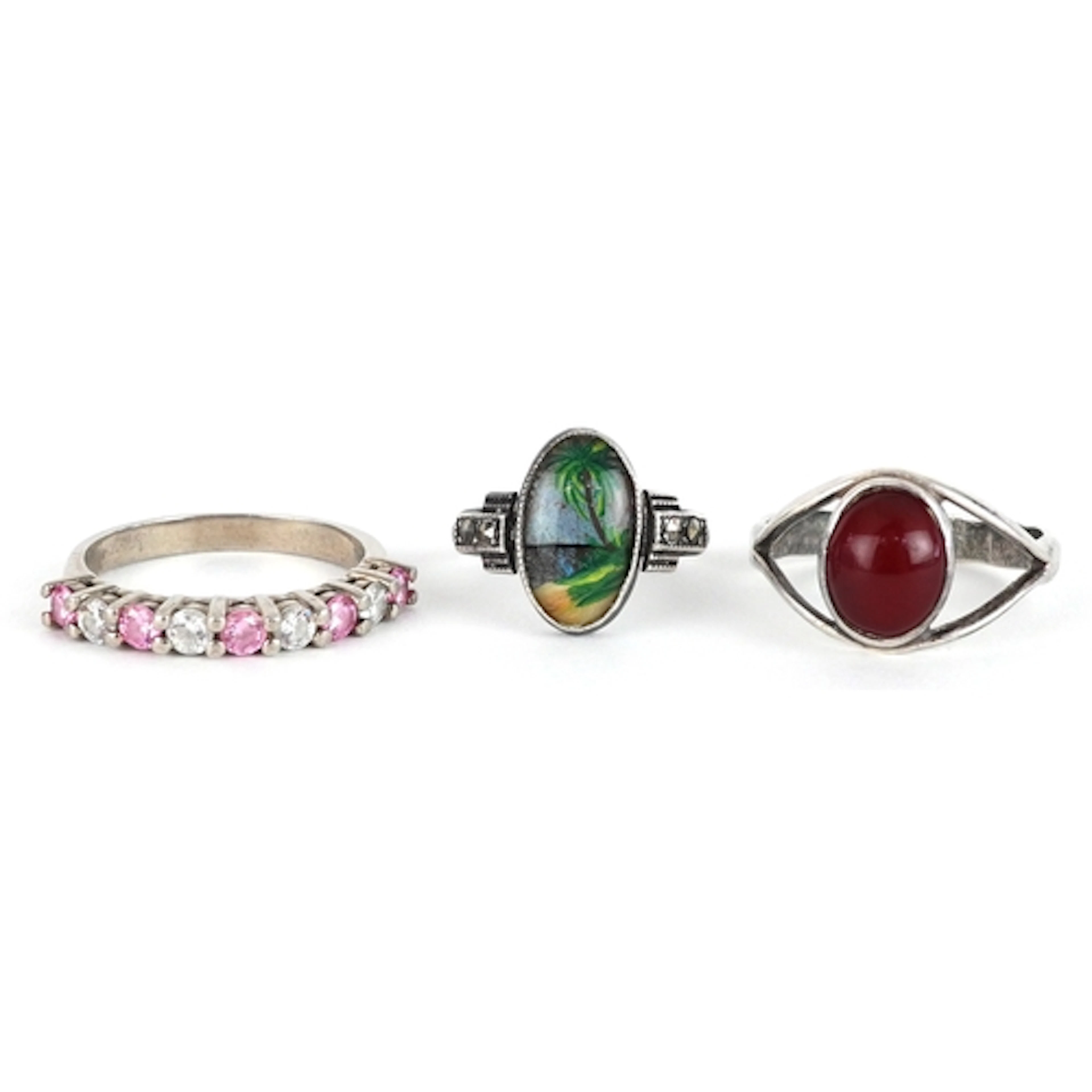Three white metal rings, two set with colourful stones and a...