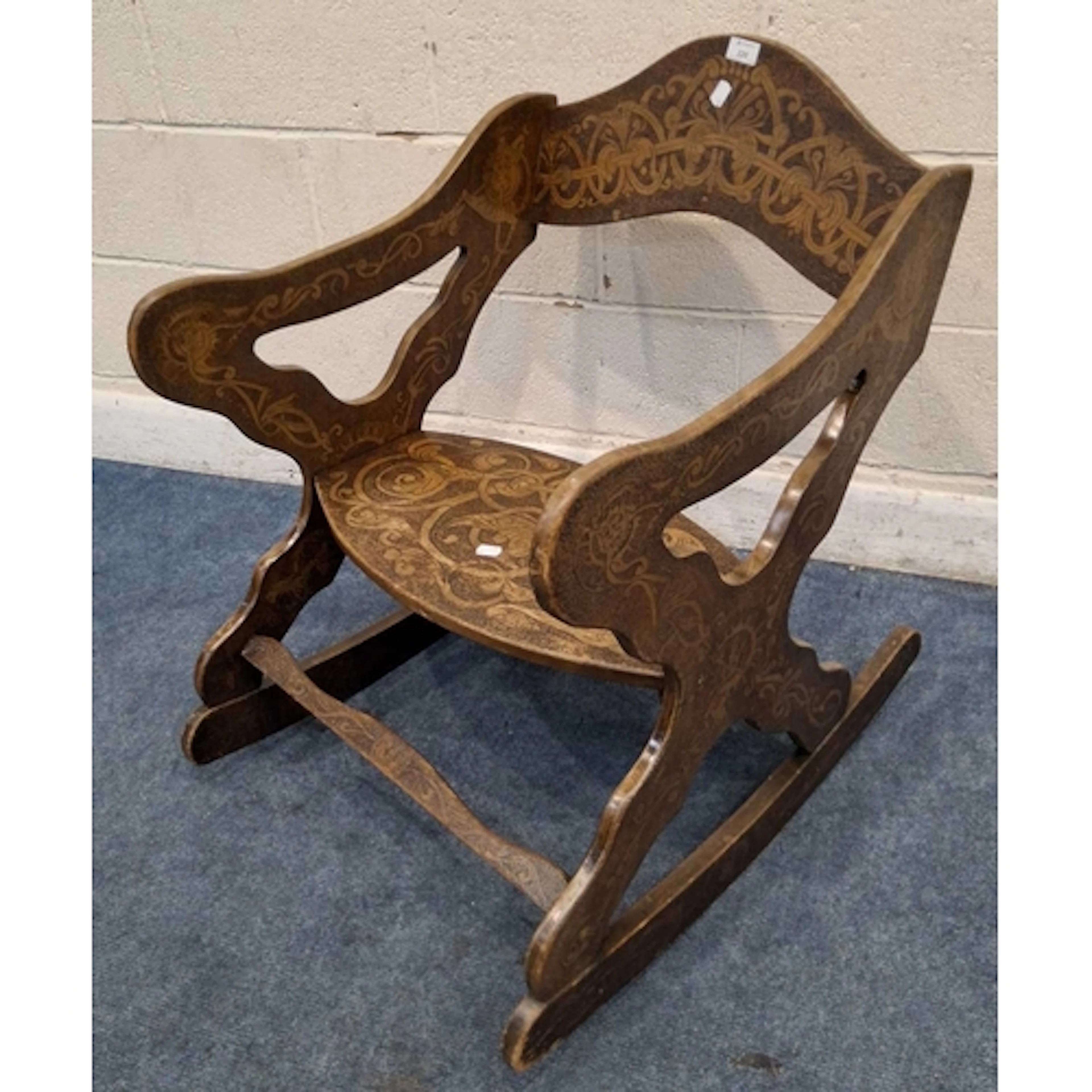 A 20TH CENTURY ROCKING CHAIR, with pokerwork, scrolled and m...
