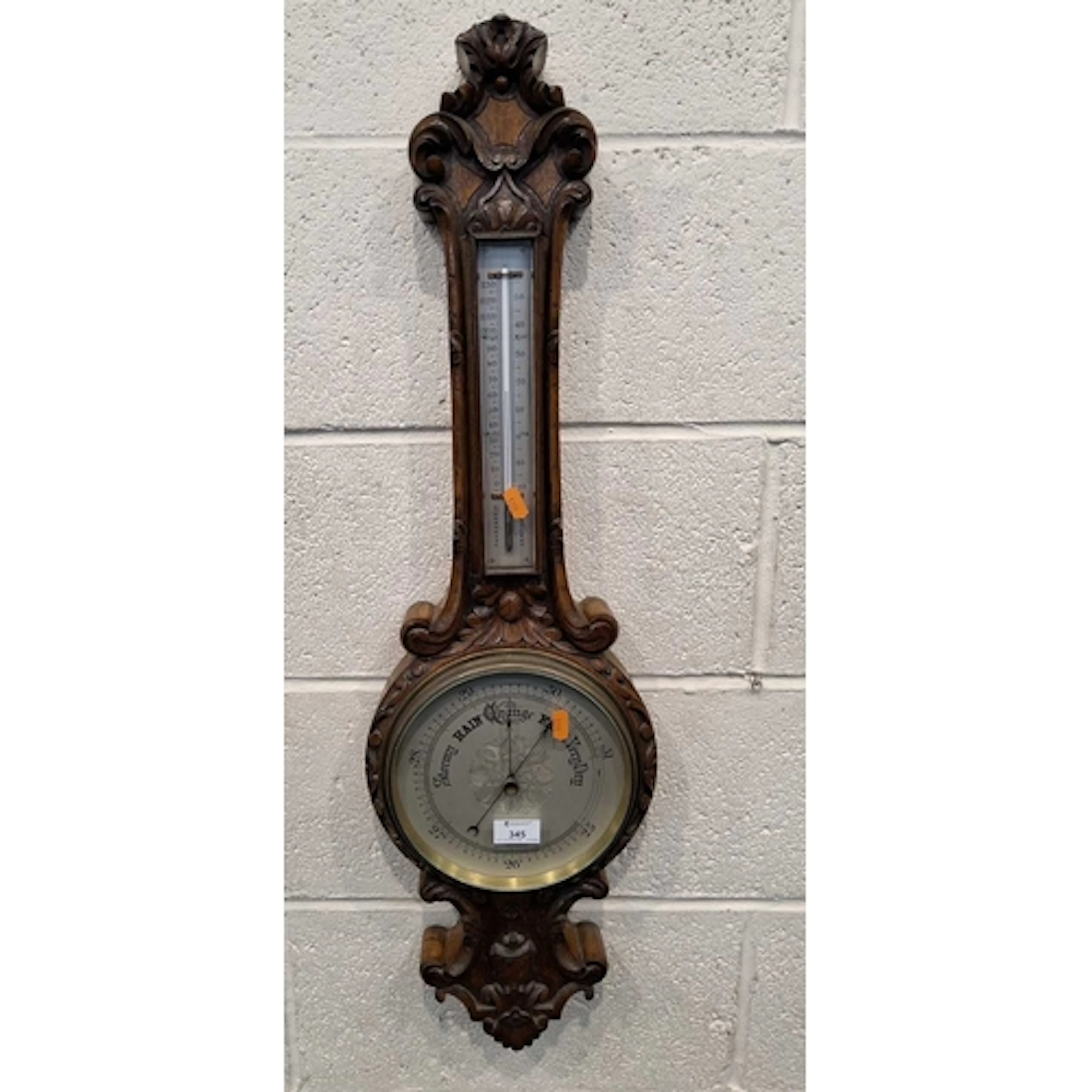 AN EARLY 20TH CENTURY OAK BAROMETER, with scrolled and folia...