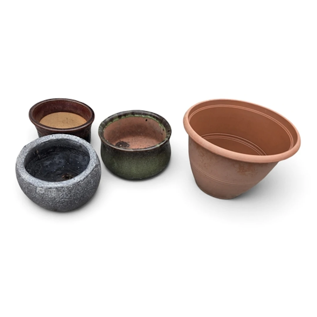 A group of small Stoneware Pots along with a plastic example...
