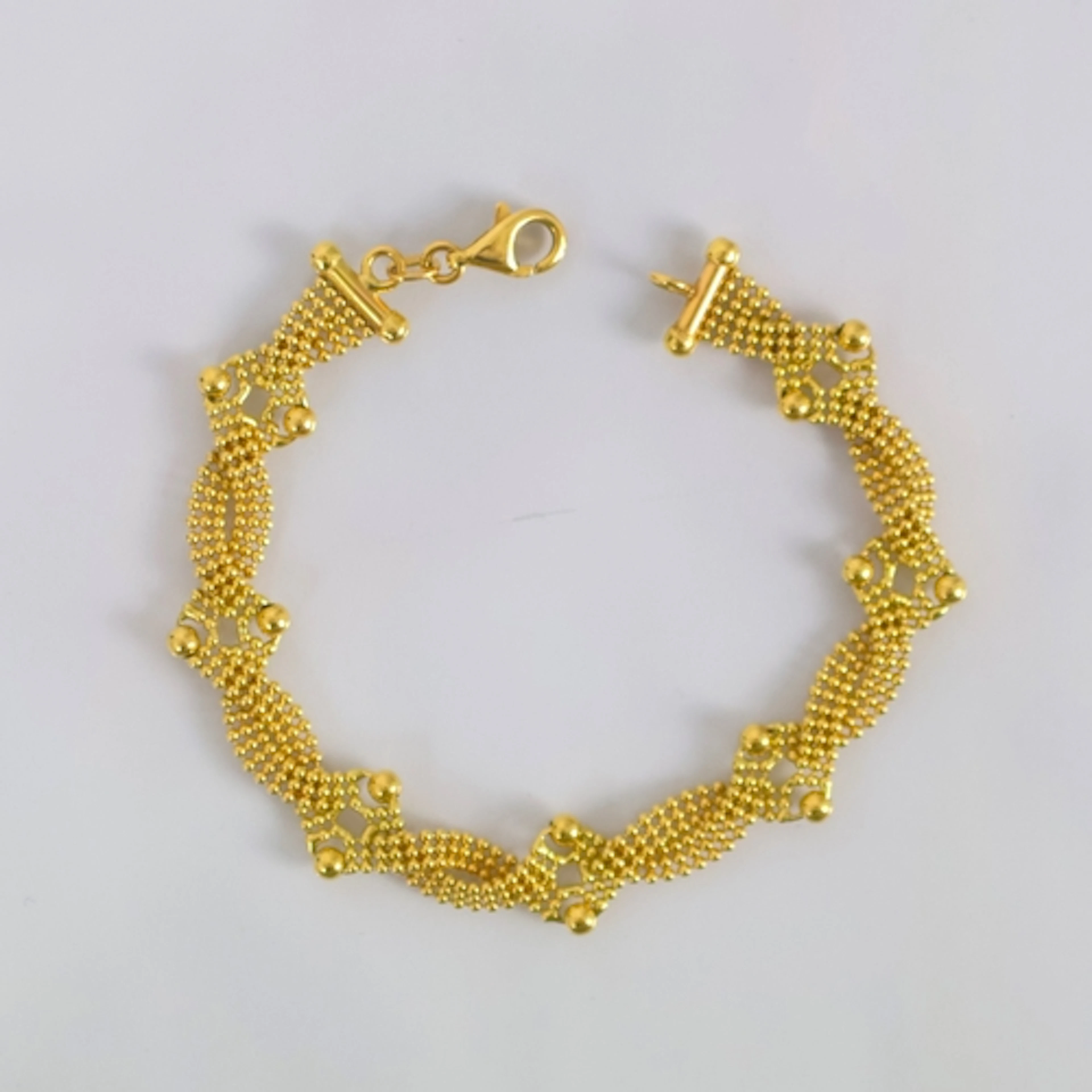 A contemporary Italian yellow metal bracelet, of beaded open...