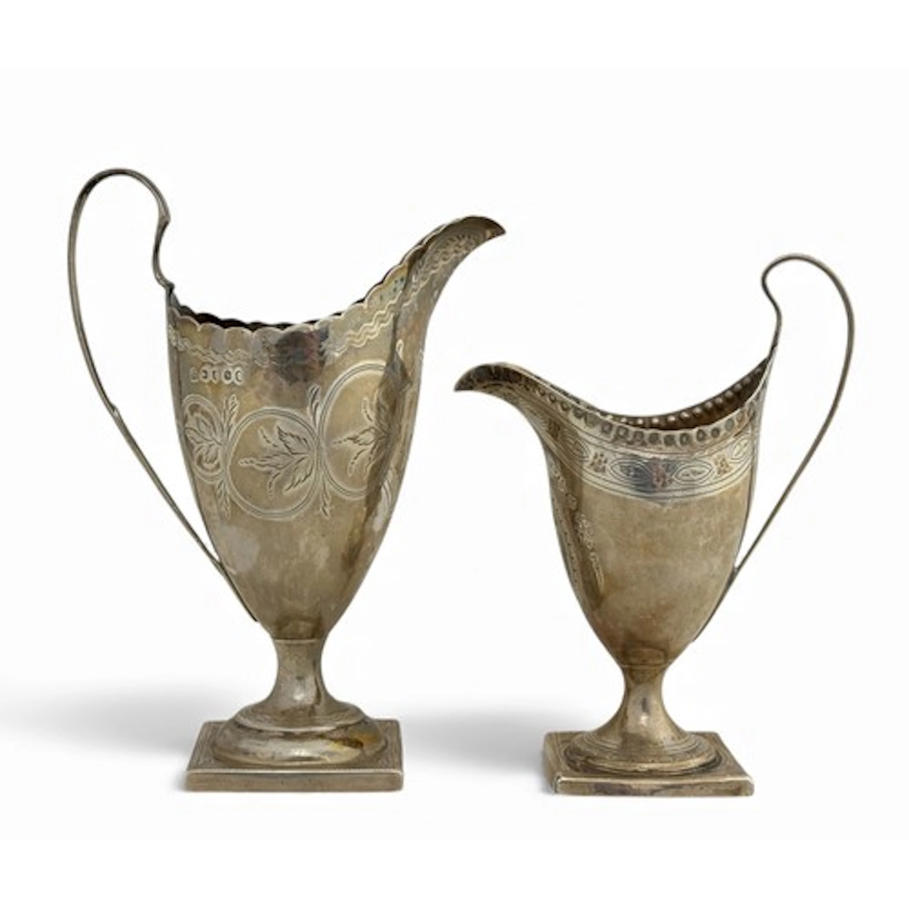 Two George III silver helmet cream jugs. A jug by George Smi...