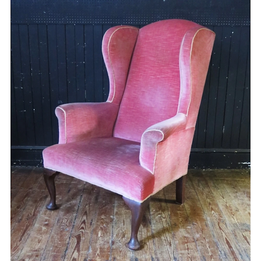 A late Georgian fully upholstered wingback armchair with stu...