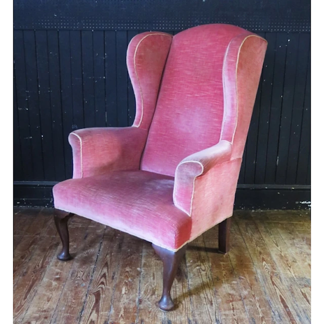 A late Georgian fully upholstered wingback armchair with stu...
