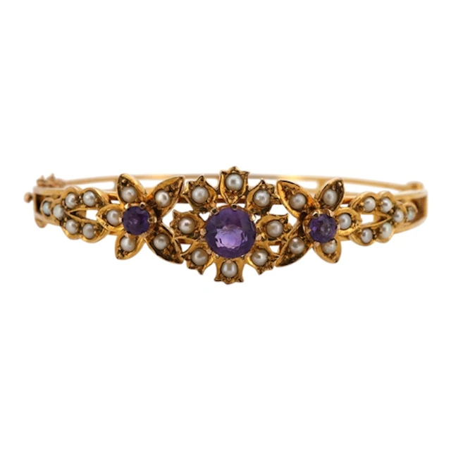An amethyst and seed pearl bangle, circa 1970, the hinged ba...