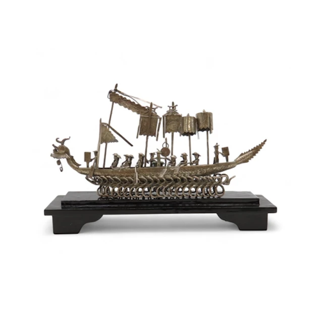 A CHINESE WHITE METAL DRAGON BOAT Numerous oarsmen seated be...