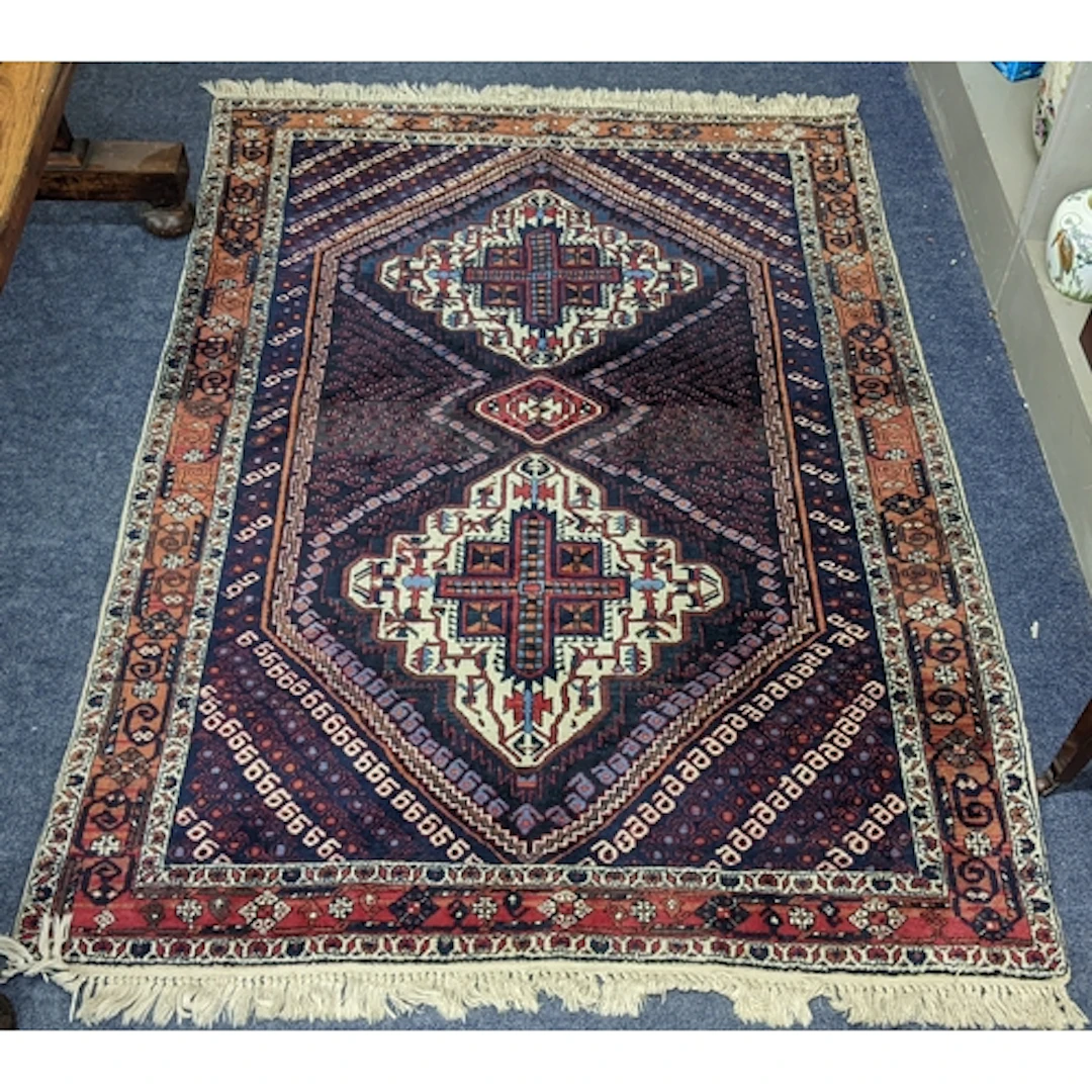 A Persian hand woven rug having geometric medallions within ...