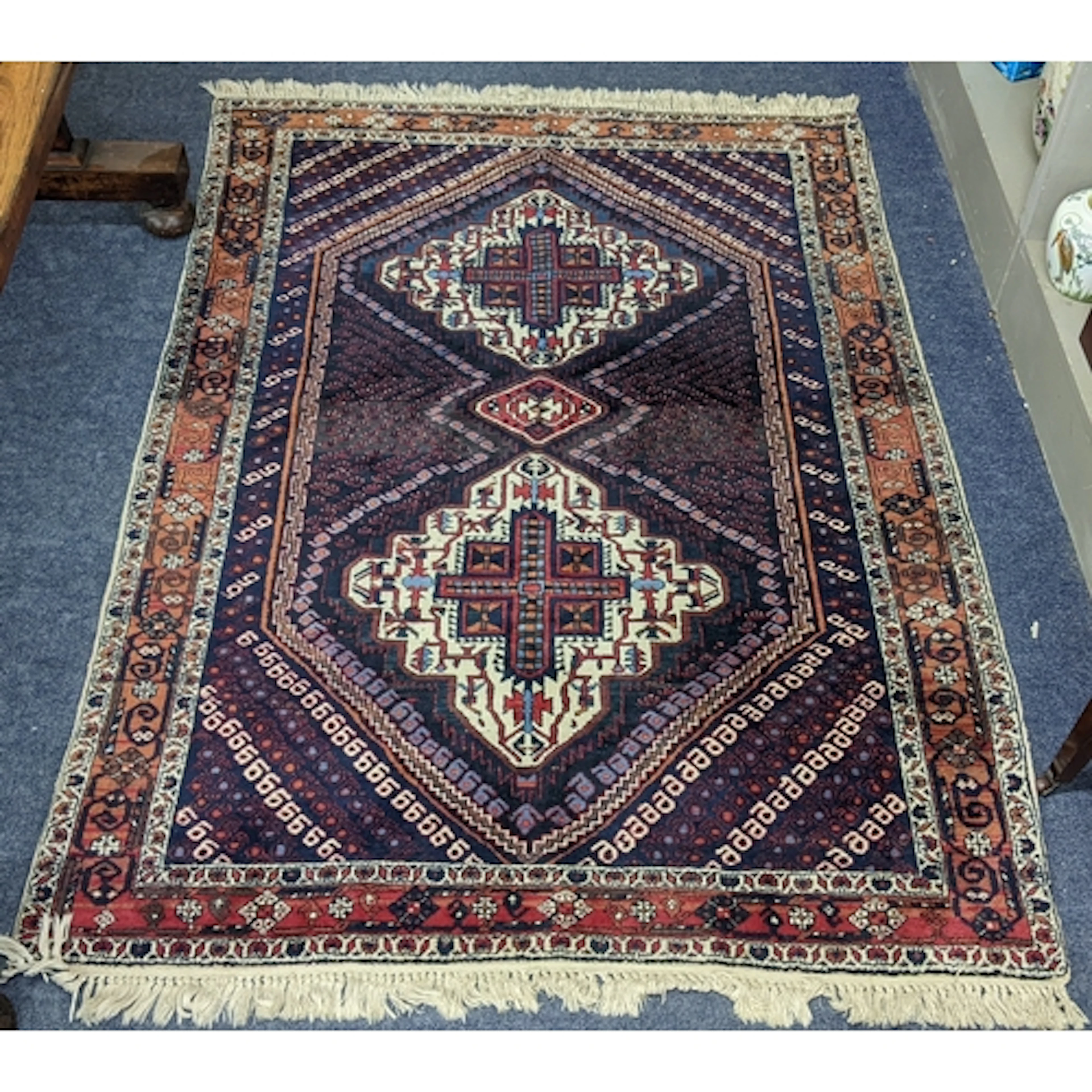 A Persian hand woven rug having geometric medallions within ...