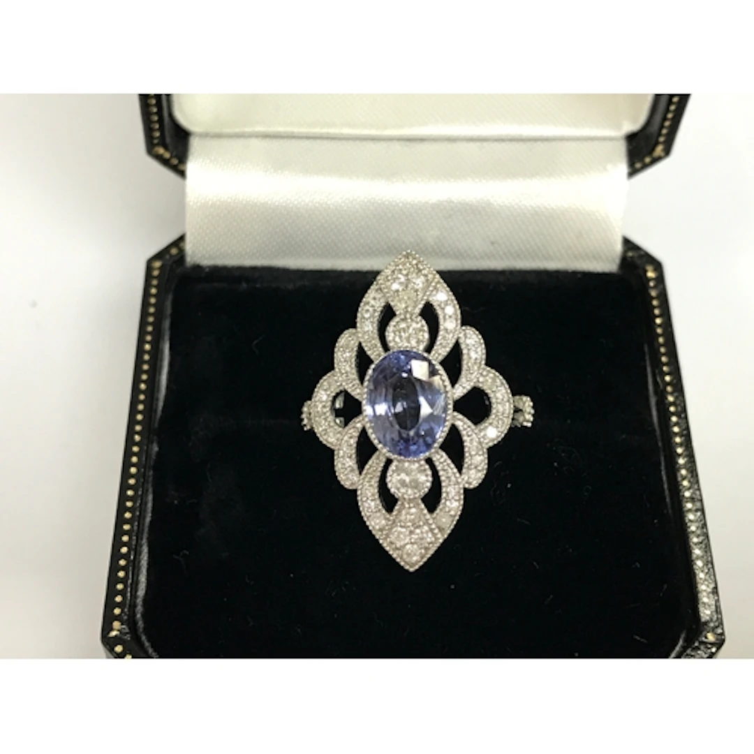 Platinum marquise shaped ring set with oval sapphire and rou...