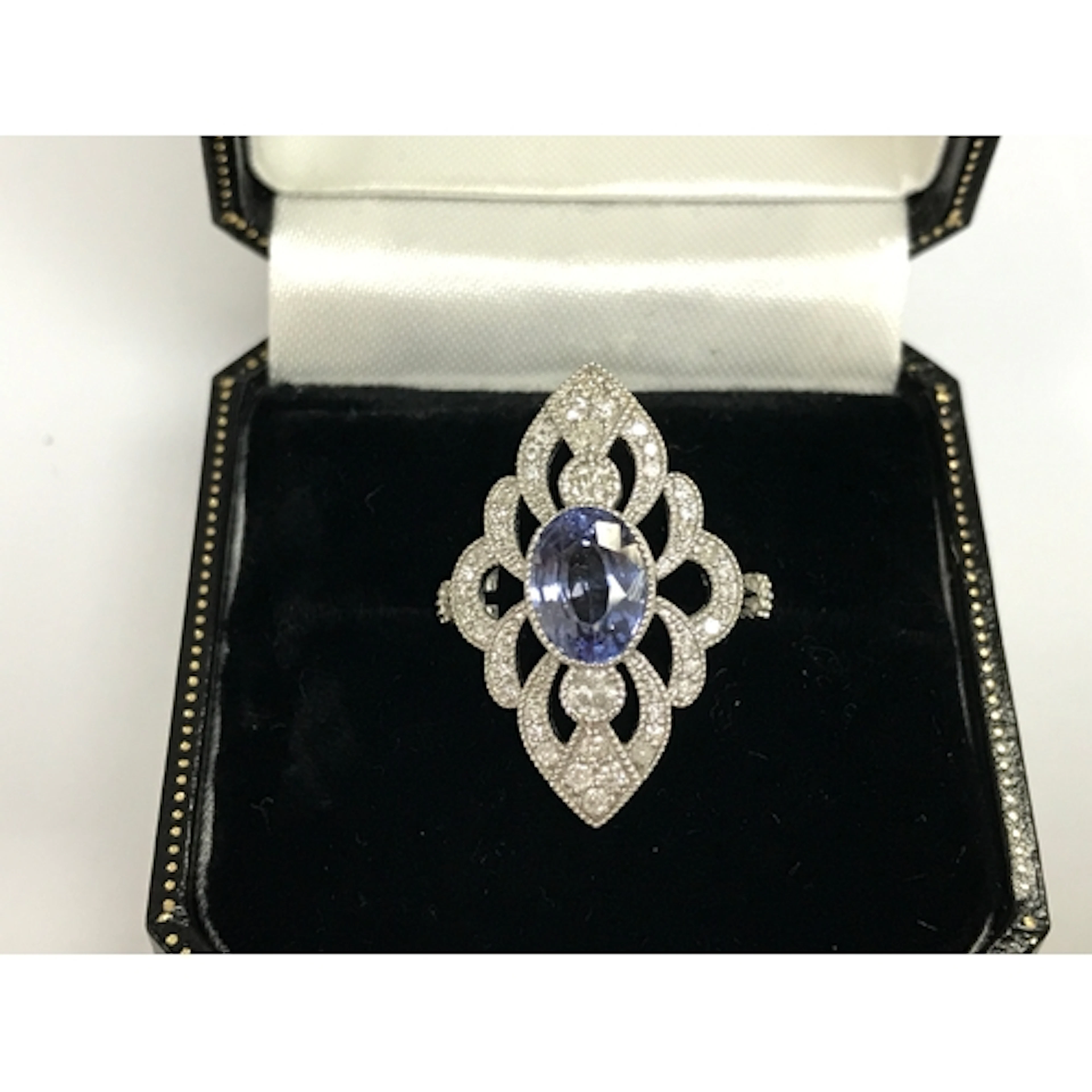 Platinum marquise shaped ring set with oval sapphire and rou...
