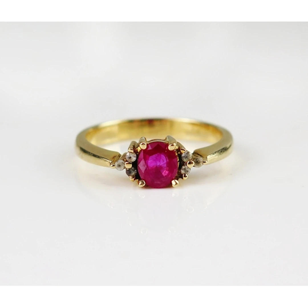 A ruby and diamond ring in an 14ct yellow gold setting, size...