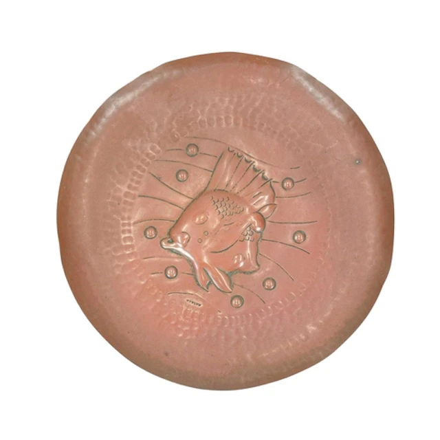 A Newlyn circular copper dish. Repousse decorated with a fis...