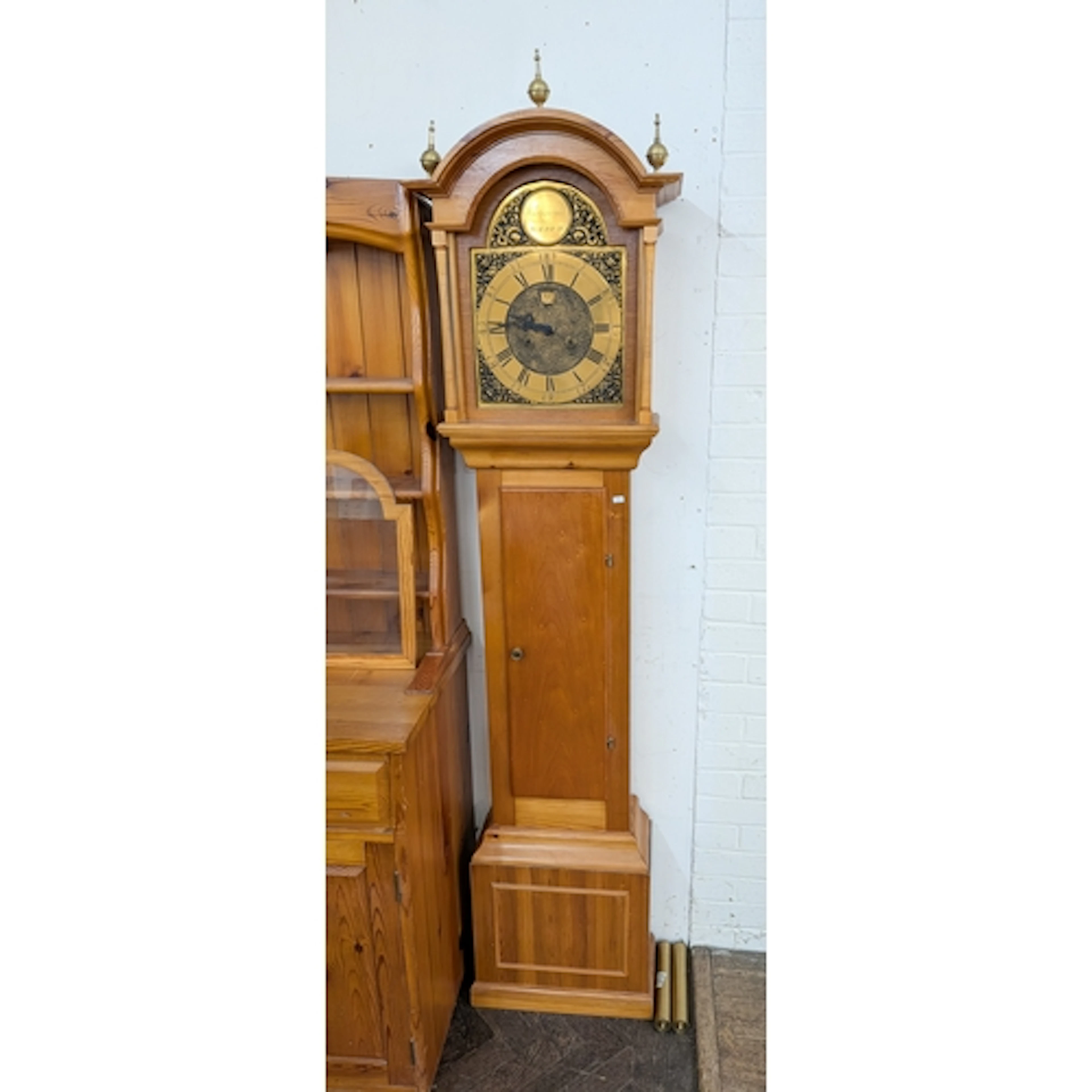 A modern Grandfather clock with arched brass dial and a pine...