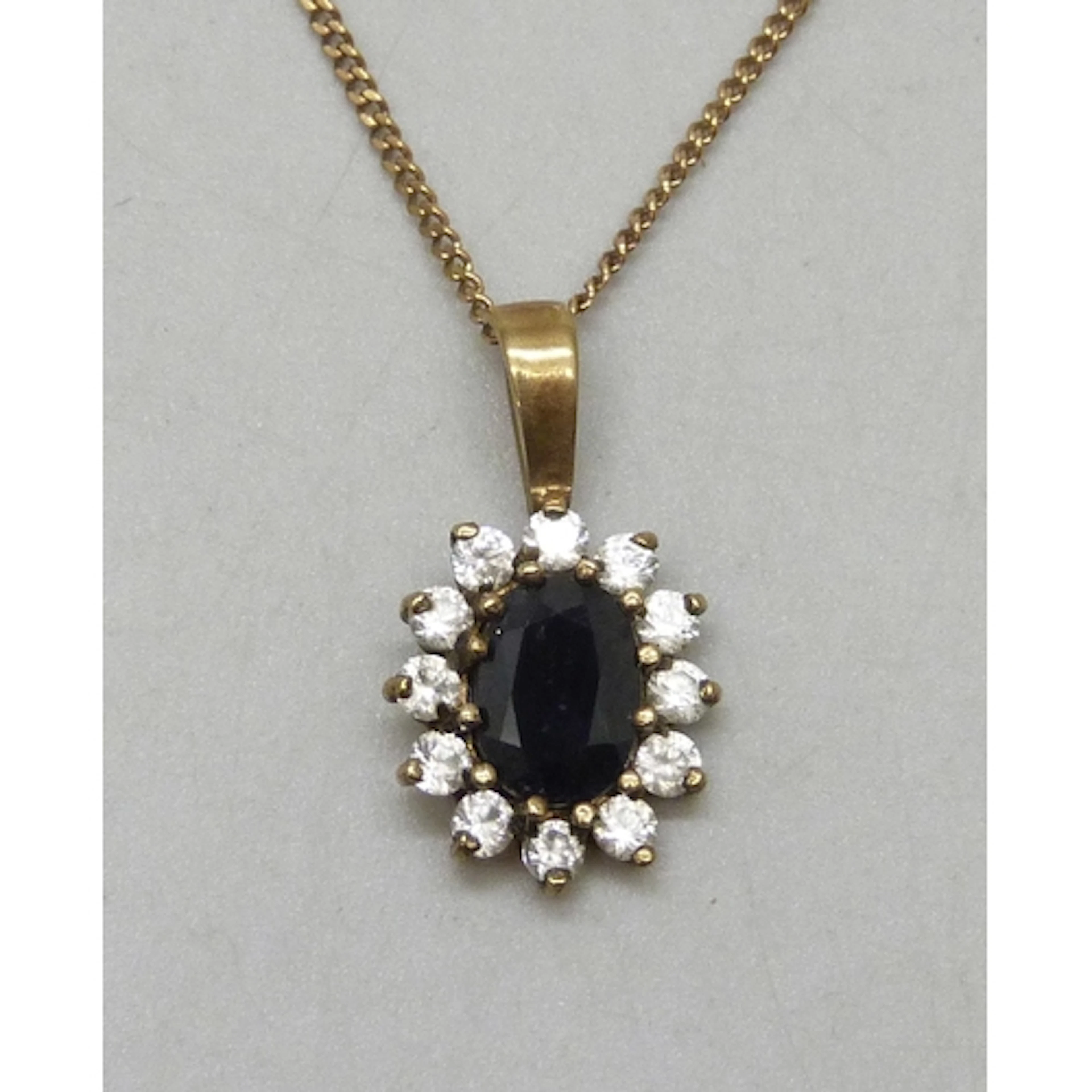 A yellow metal, sapphire and white stone cluster pendant, 1....