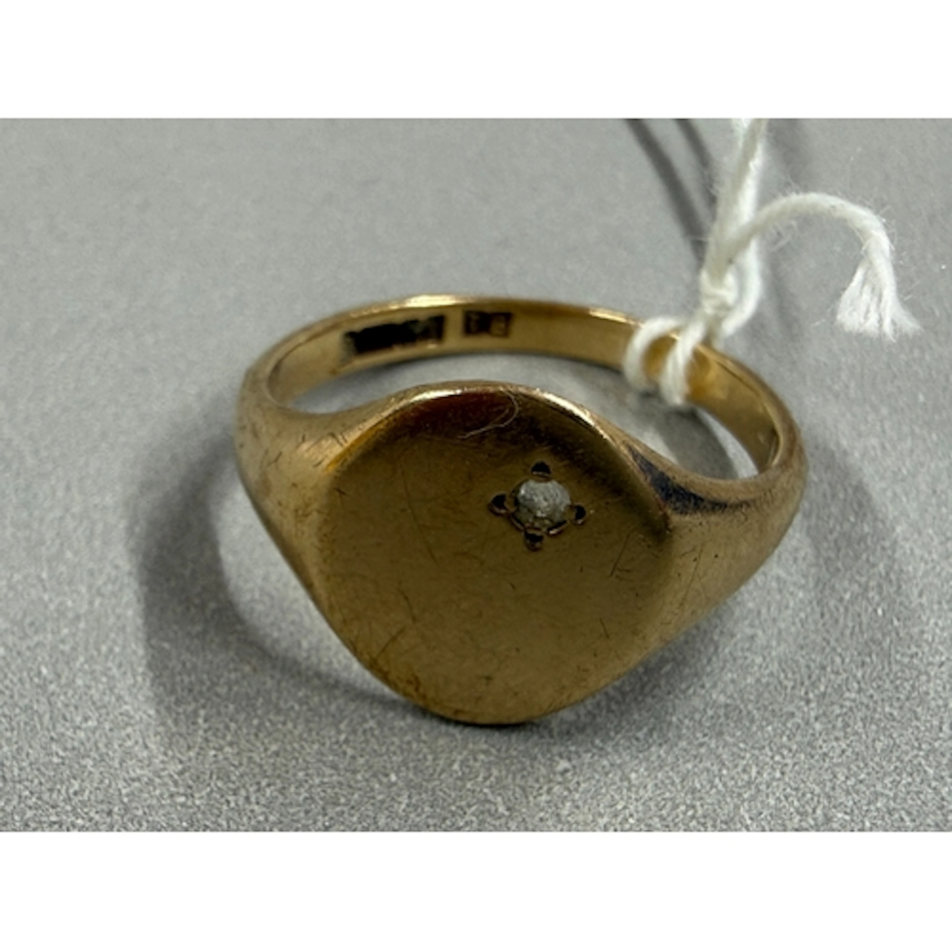 Jewellery: a 9ct gold signet ring, the plain table set a sin...