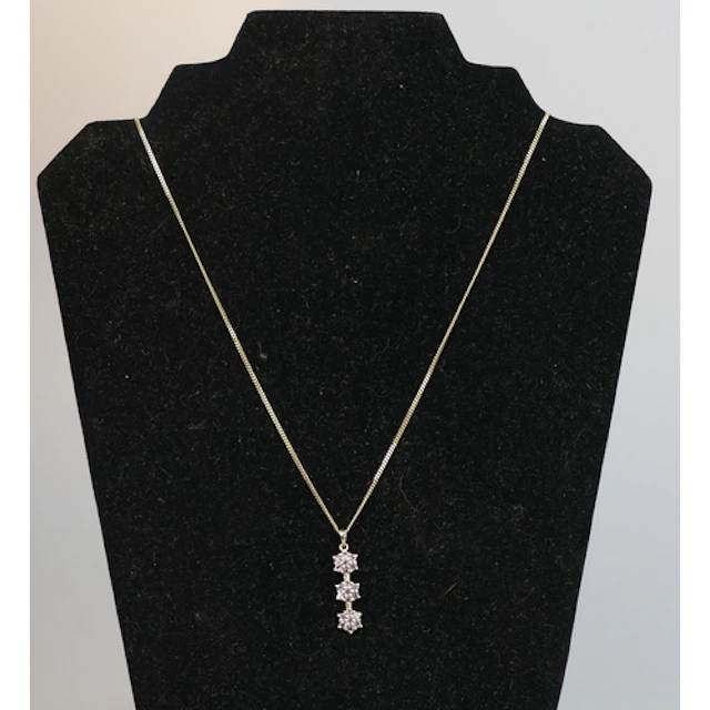 A gem set pendant in a 10K gold setting and on a 64cm 9ct go...