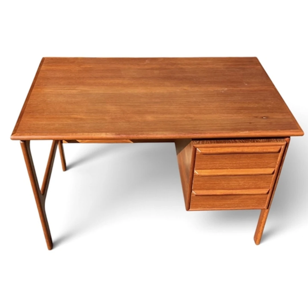 A MID-CENTURY STYLE TEAK DESK With flank of drawers to the r...