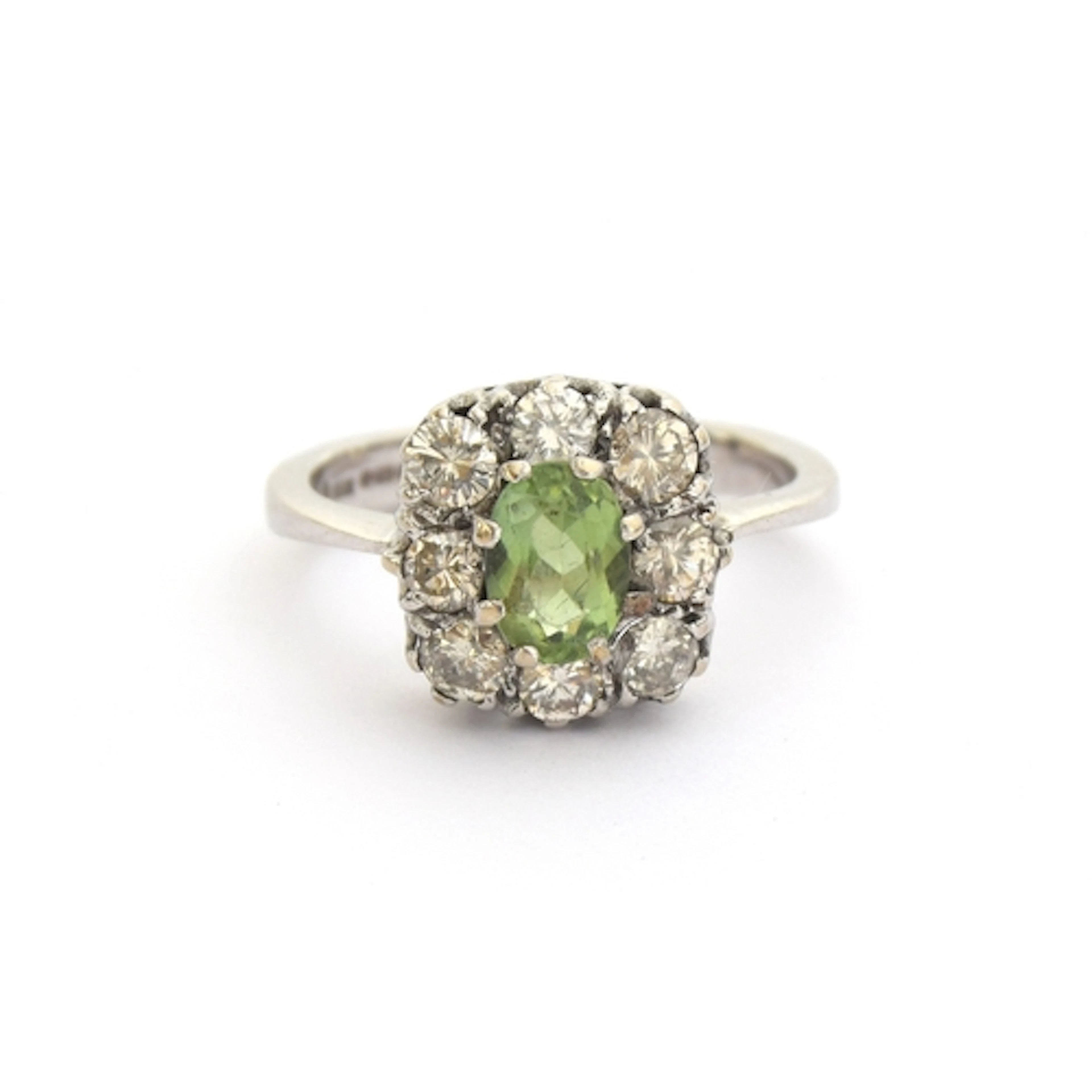An 18ct white gold, diamond and peridot cluster ring, the ov...