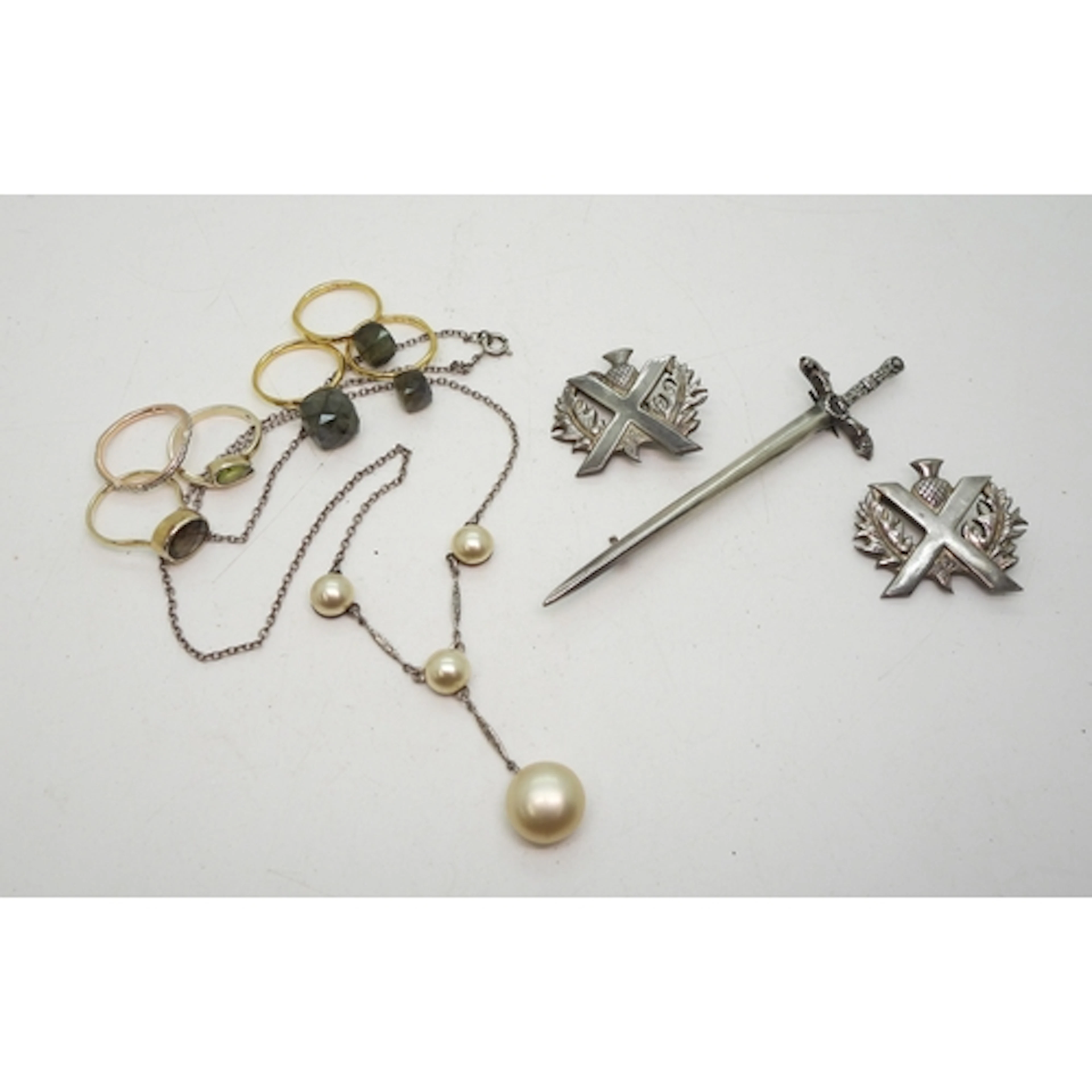 A silver Robert Allison sword brooch, two thistle brooches, ...