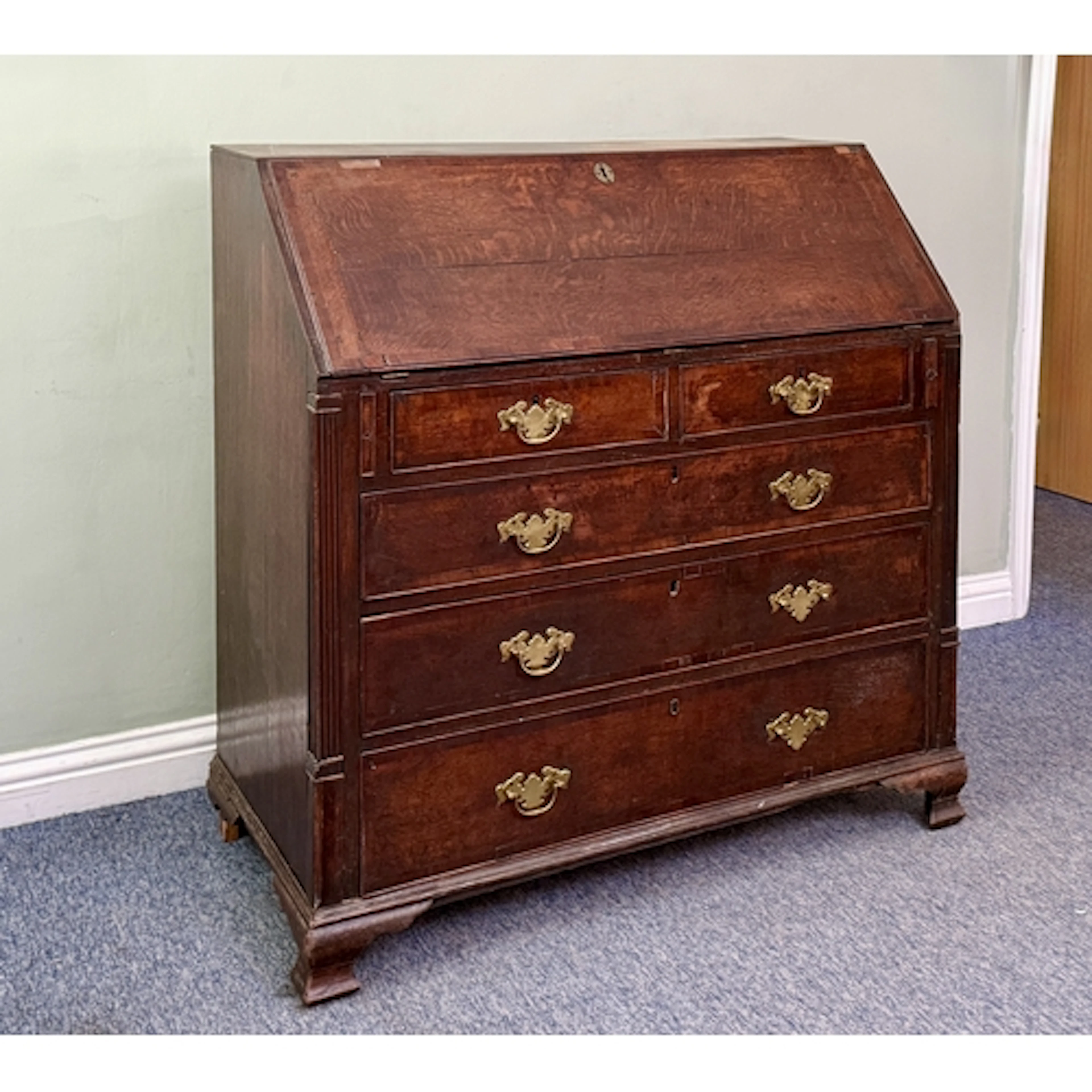 A George III oak and mahogany cross banded bureau of large p...