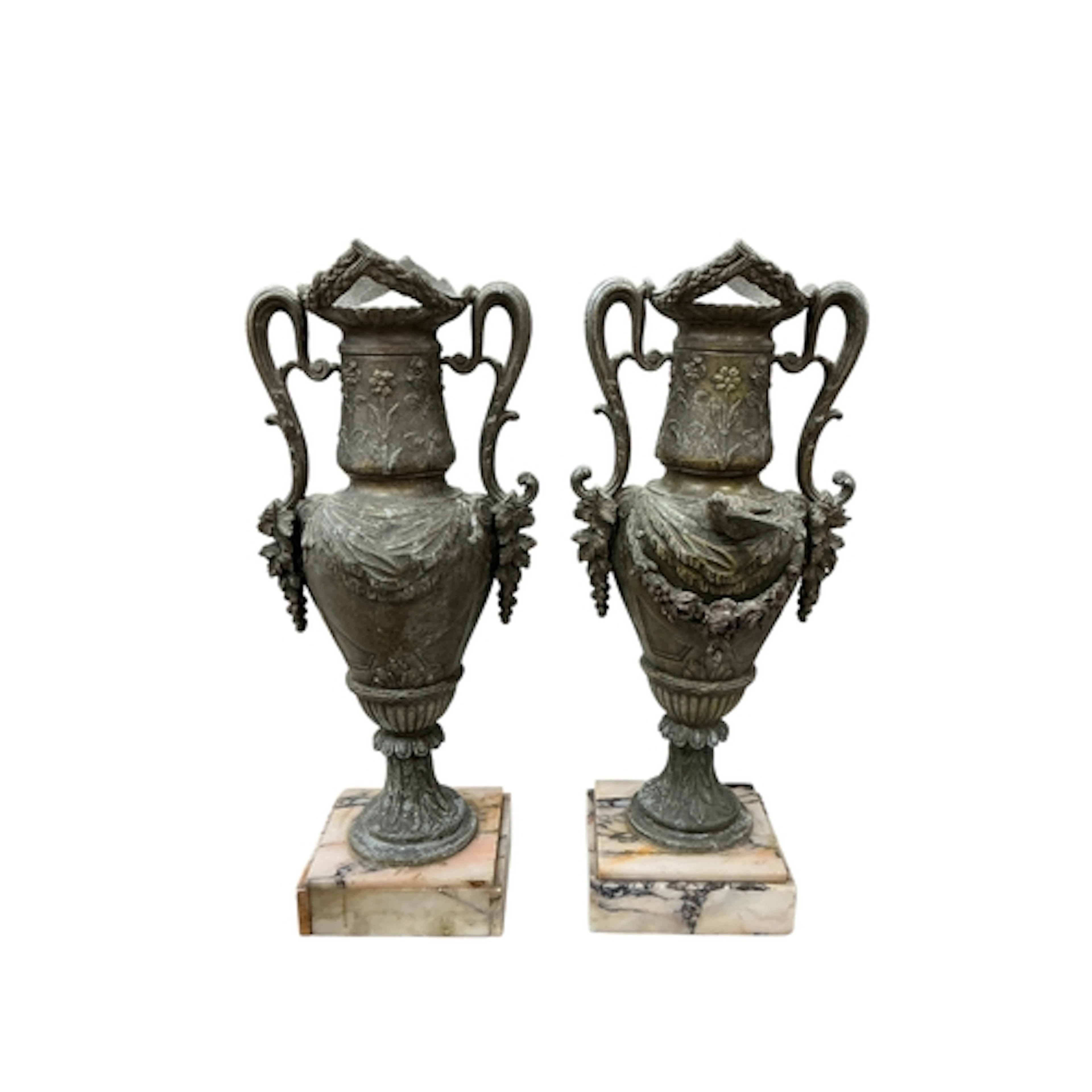 A pair of spelter twin handled urns raised on marble bases, ...