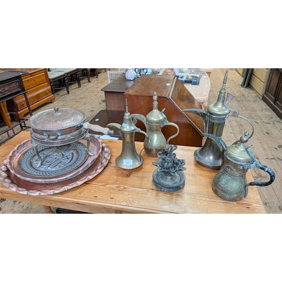 Four Turkish brass coffee pots together with a copper pan on...
