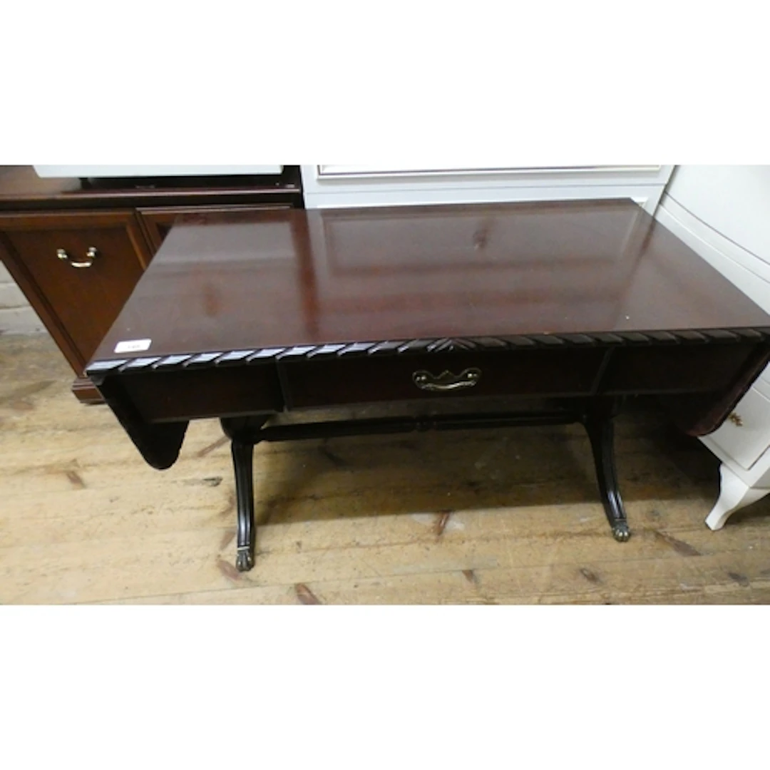 A long mahogany drop leaf coffee table with fitted drawer an...