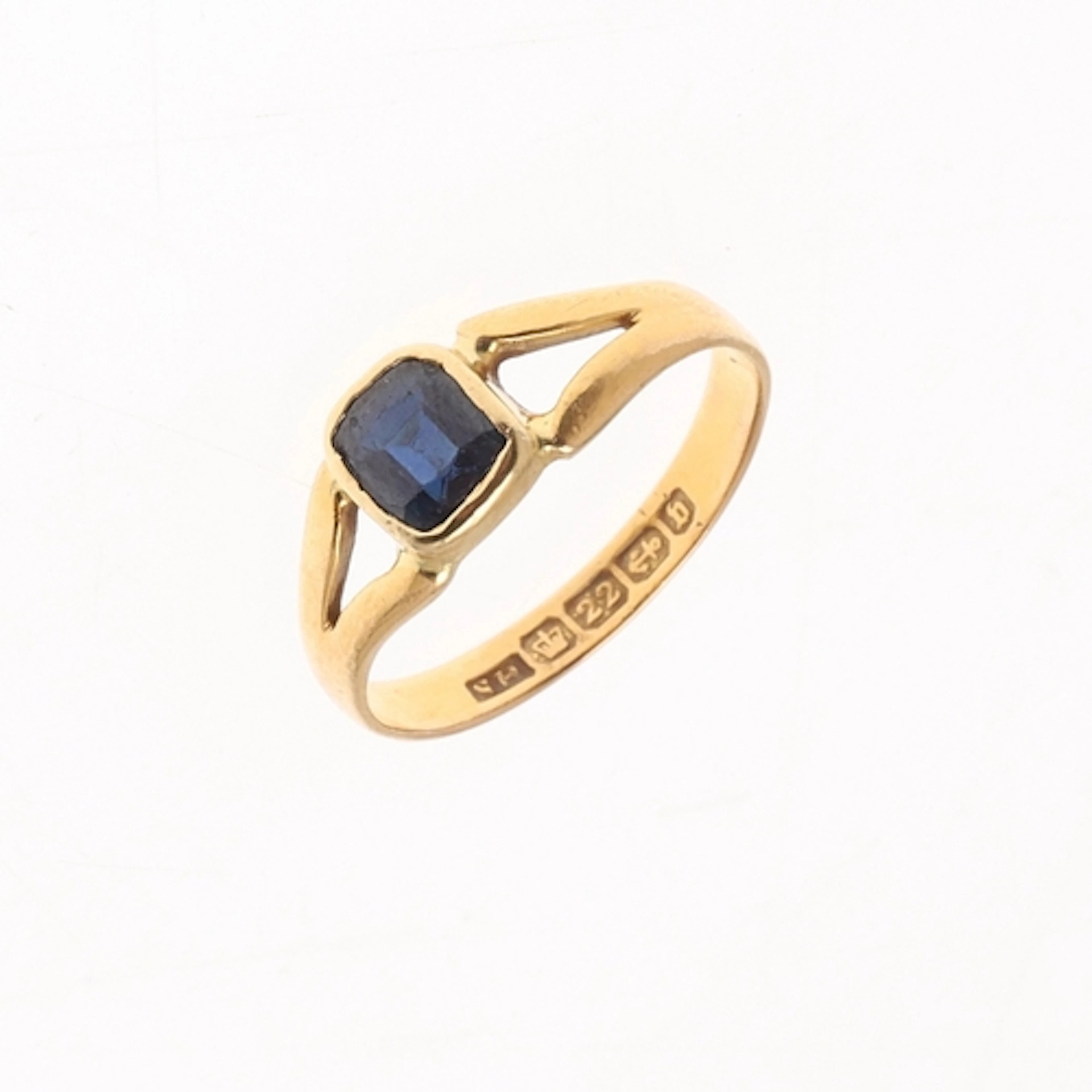 A SAPPHIRE AND 22CT GOLD RING. the 22ct gold ring is mounted...