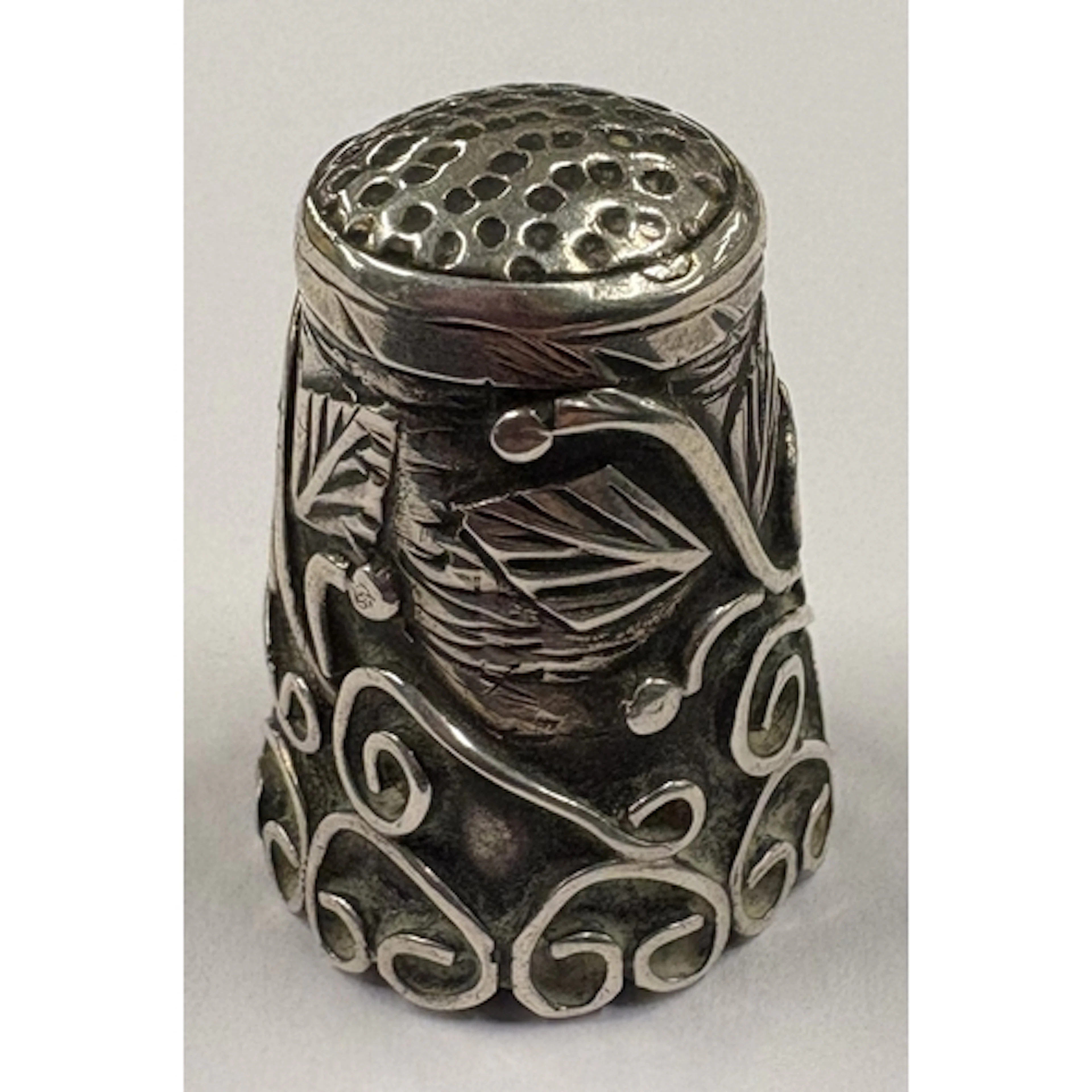 An American Sterling silver thimble with chased decoration, ...