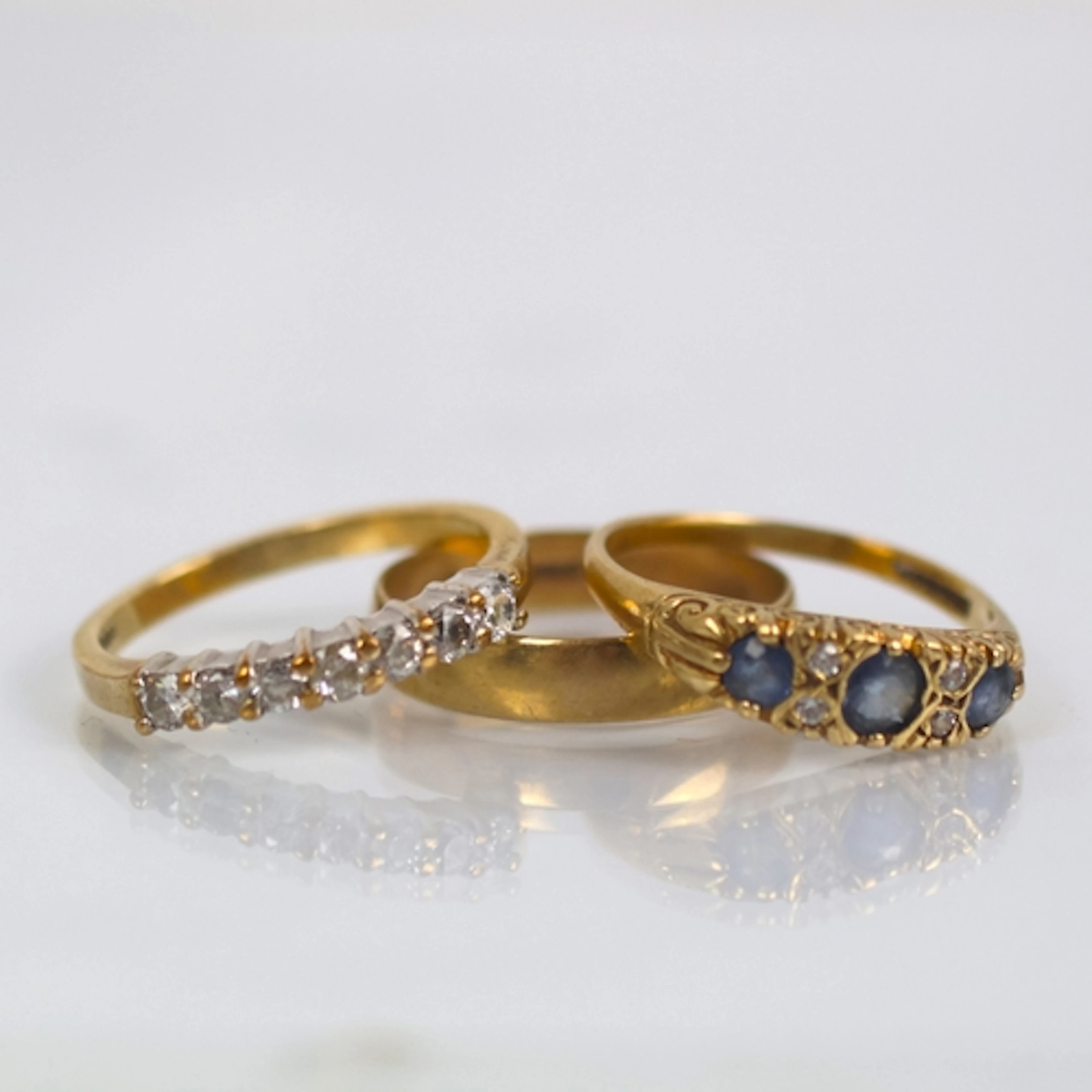 A selection of three 9ct gold dress rings, including a weddi...