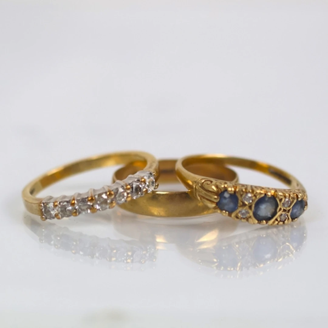 A selection of three 9ct gold dress rings, including a weddi...