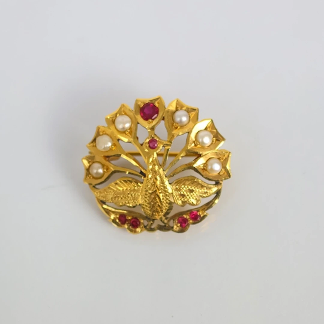 A Middle Eastern yellow metal brooch, designed as a peacock ...
