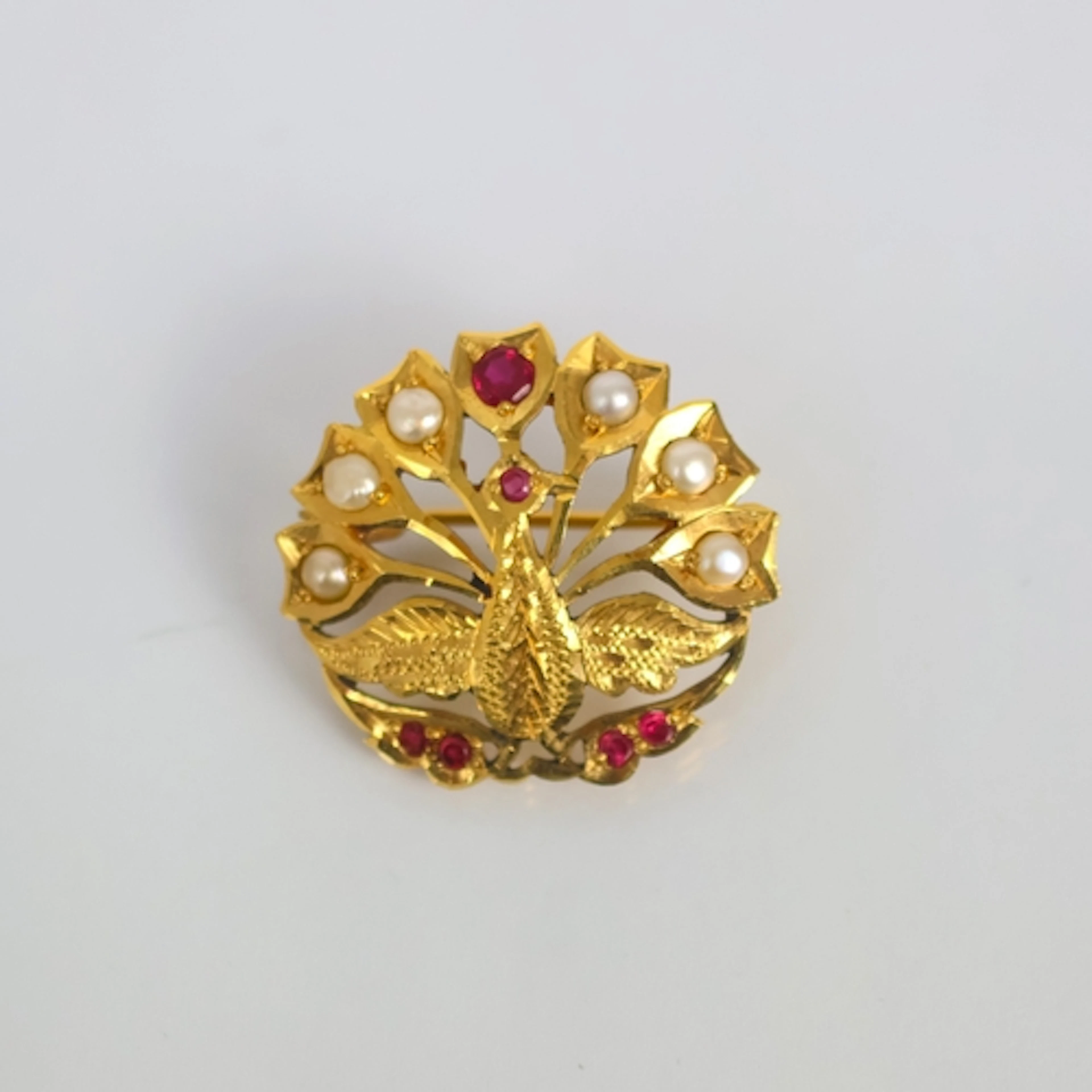 A Middle Eastern yellow metal brooch, designed as a peacock ...