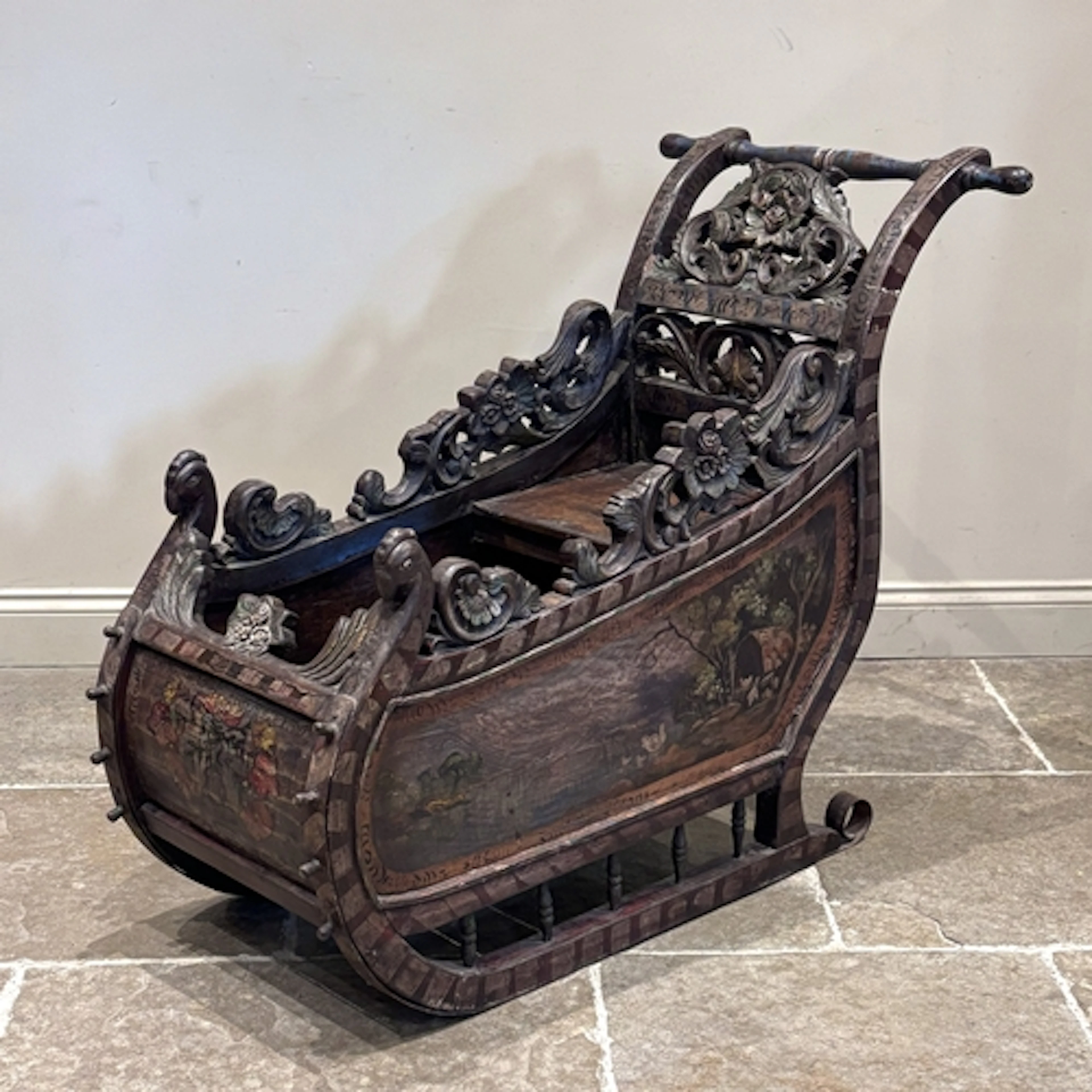 A continental carved and painted wooden sleigh, probably ear...