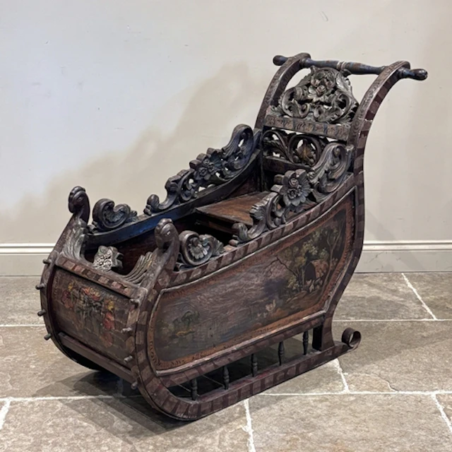 A continental carved and painted wooden sleigh, probably ear...