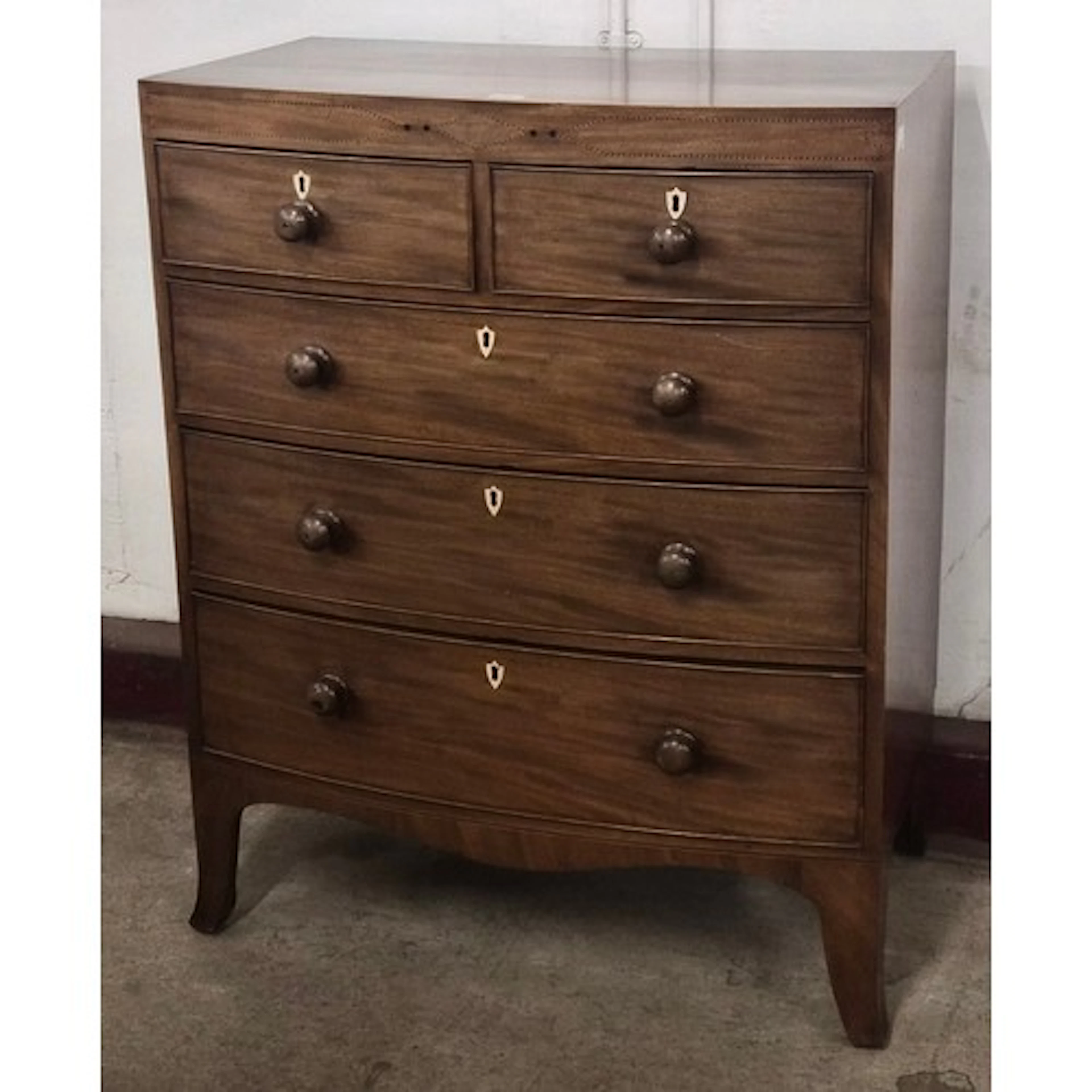 A George IV inlaid mahogany bowfront chest of drawers. Non-T...