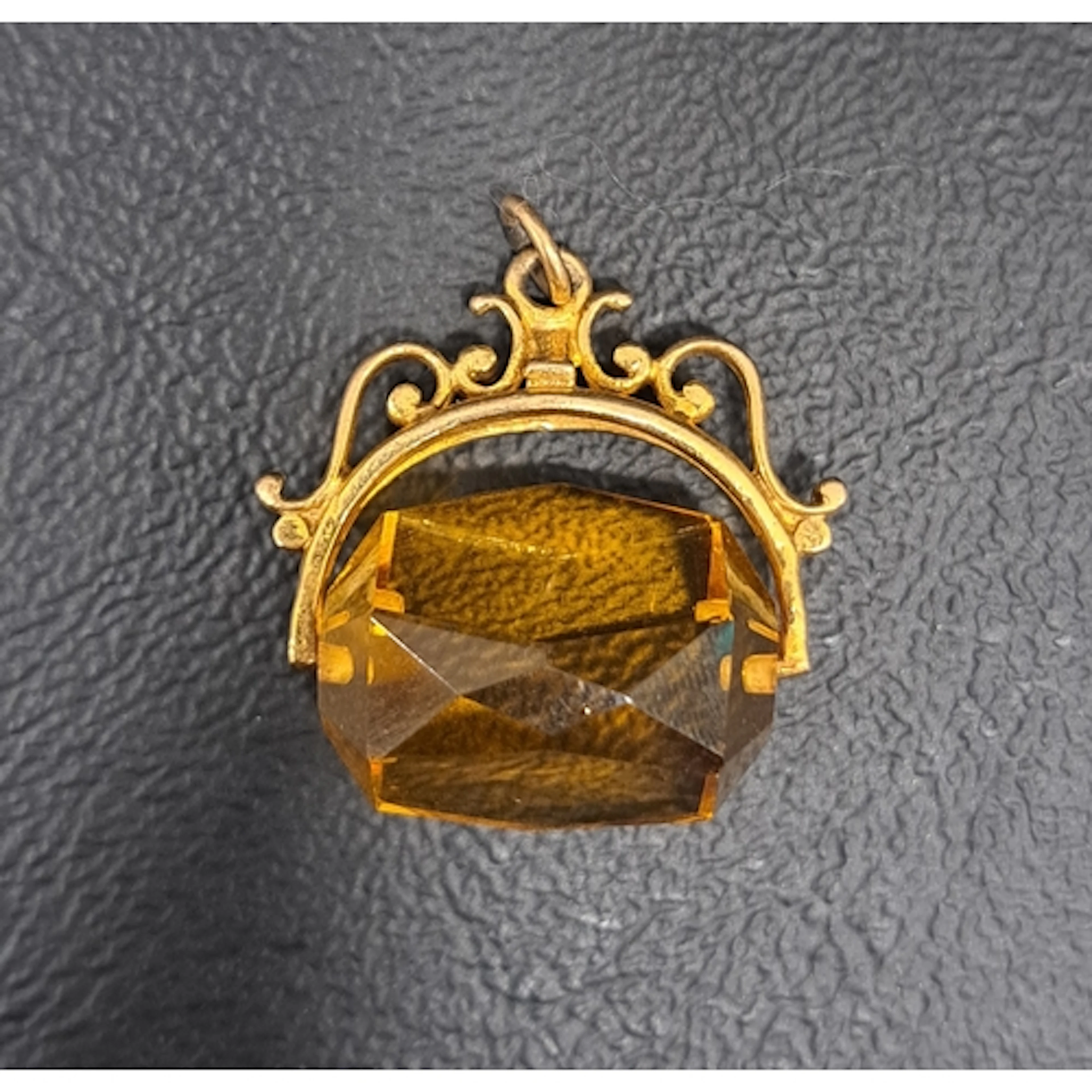 NINE CARAT GOLD MOUNTED SWIVEL FOB with faceted amber colour...