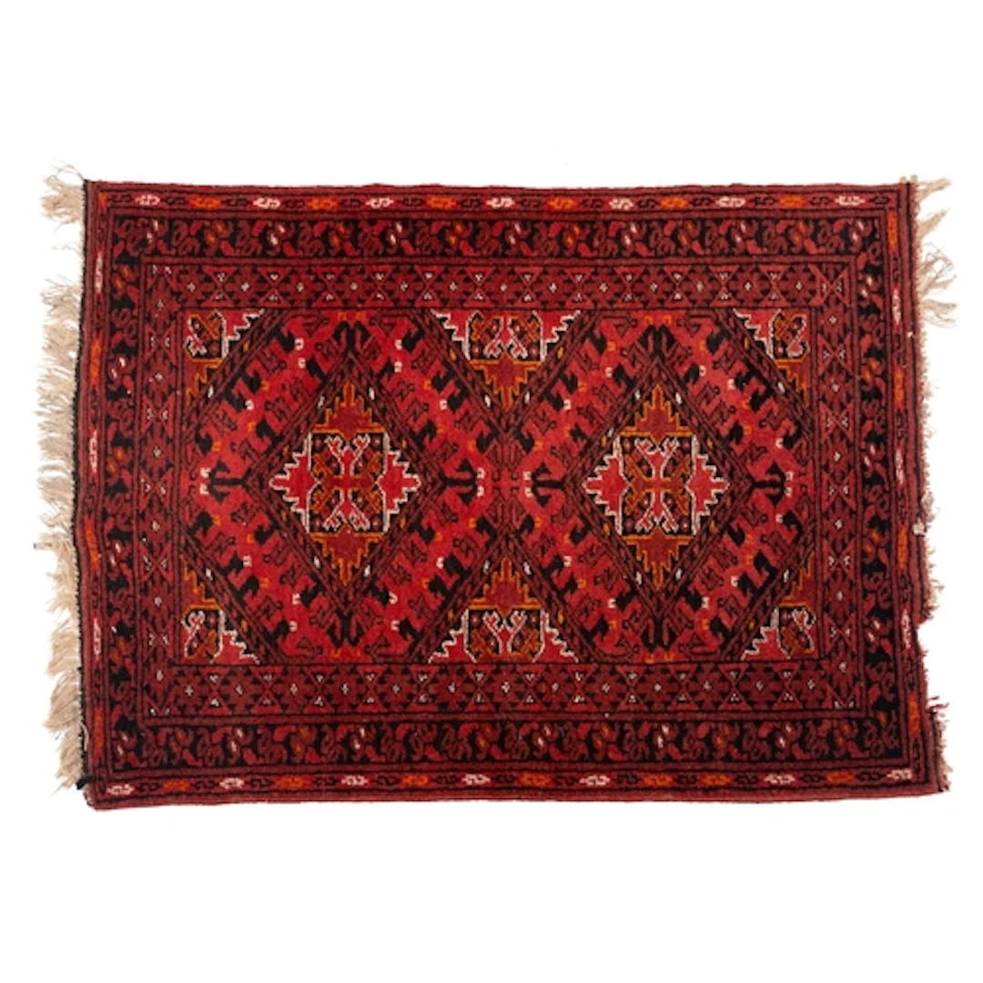 An Afghan Turkoman rug, the tomato red field with twin lozen...