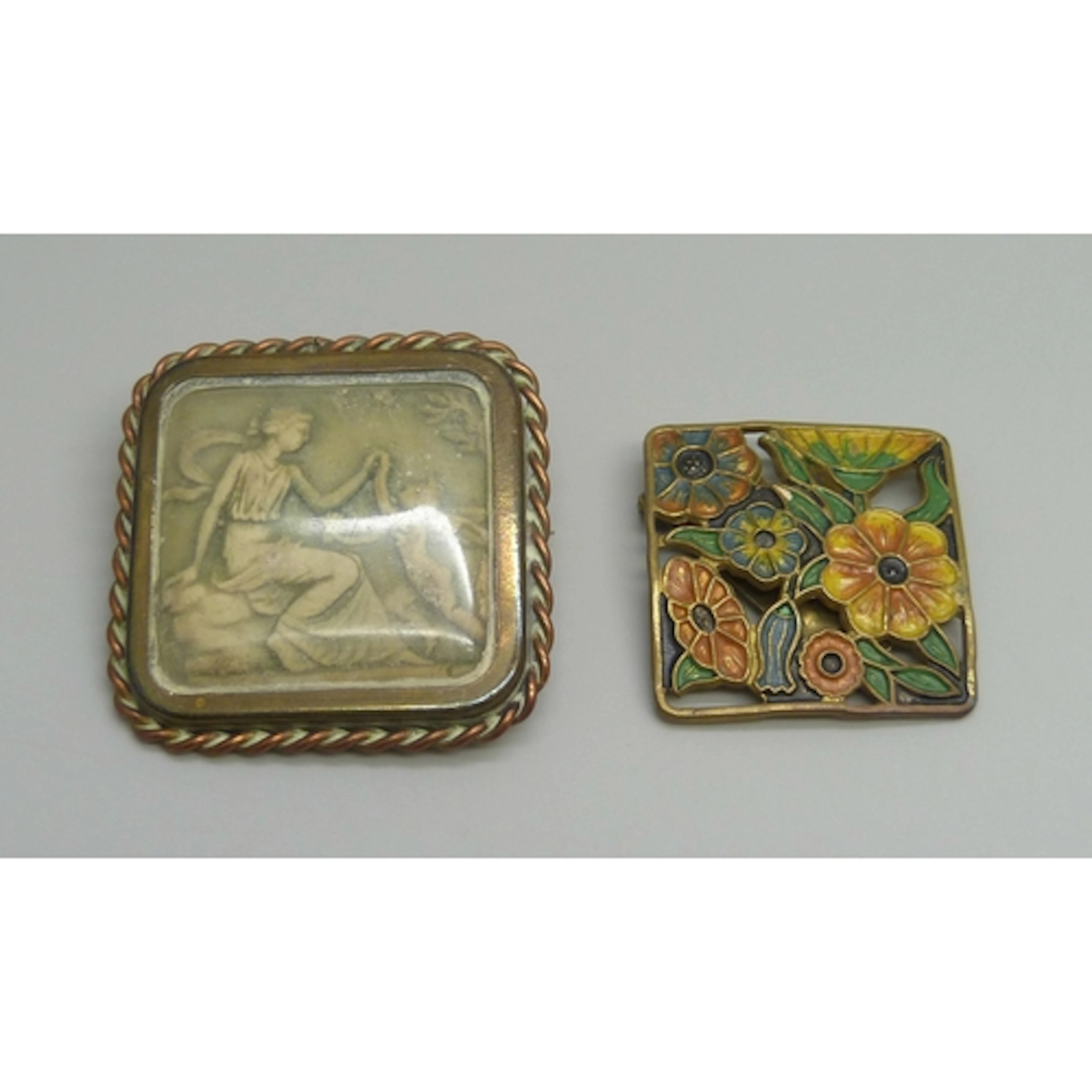 A brooch containing a carved scene depicting a lady and cher...