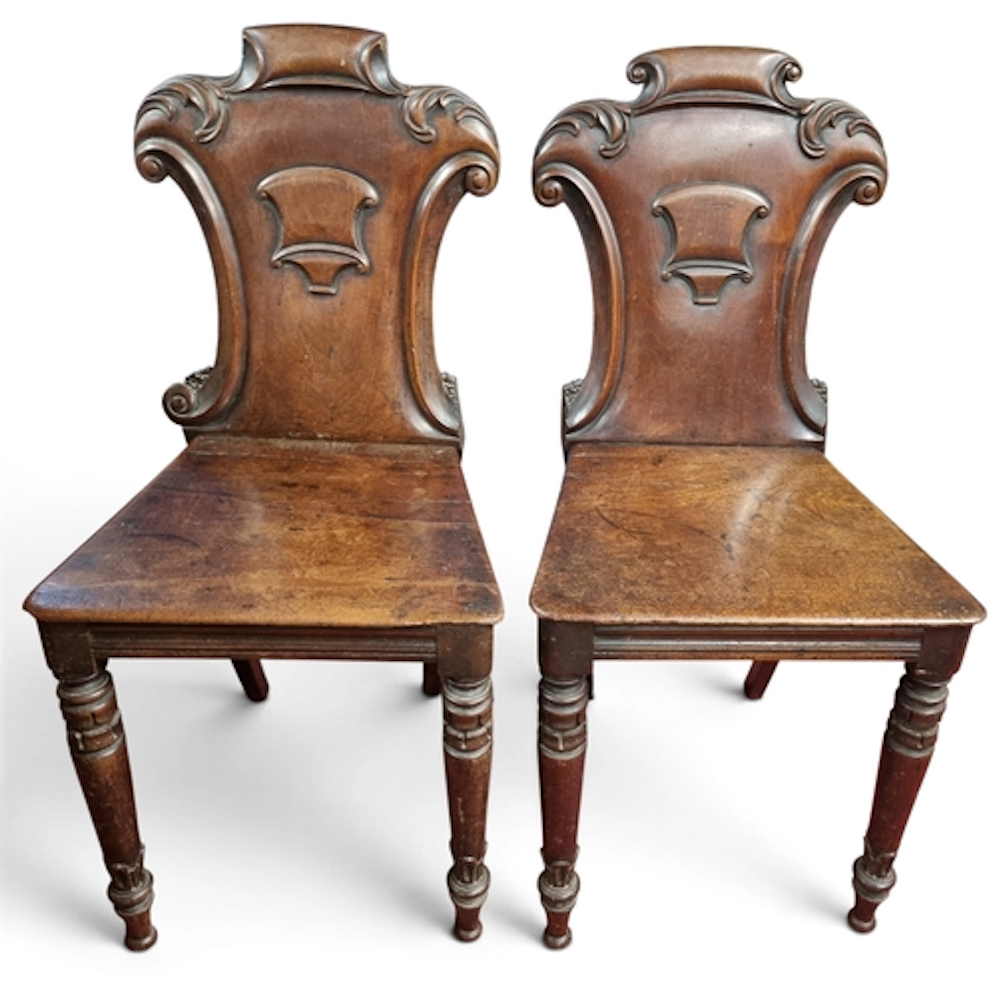 A pair of 19th Century Mahogany Hall Chairs with armorial ca...