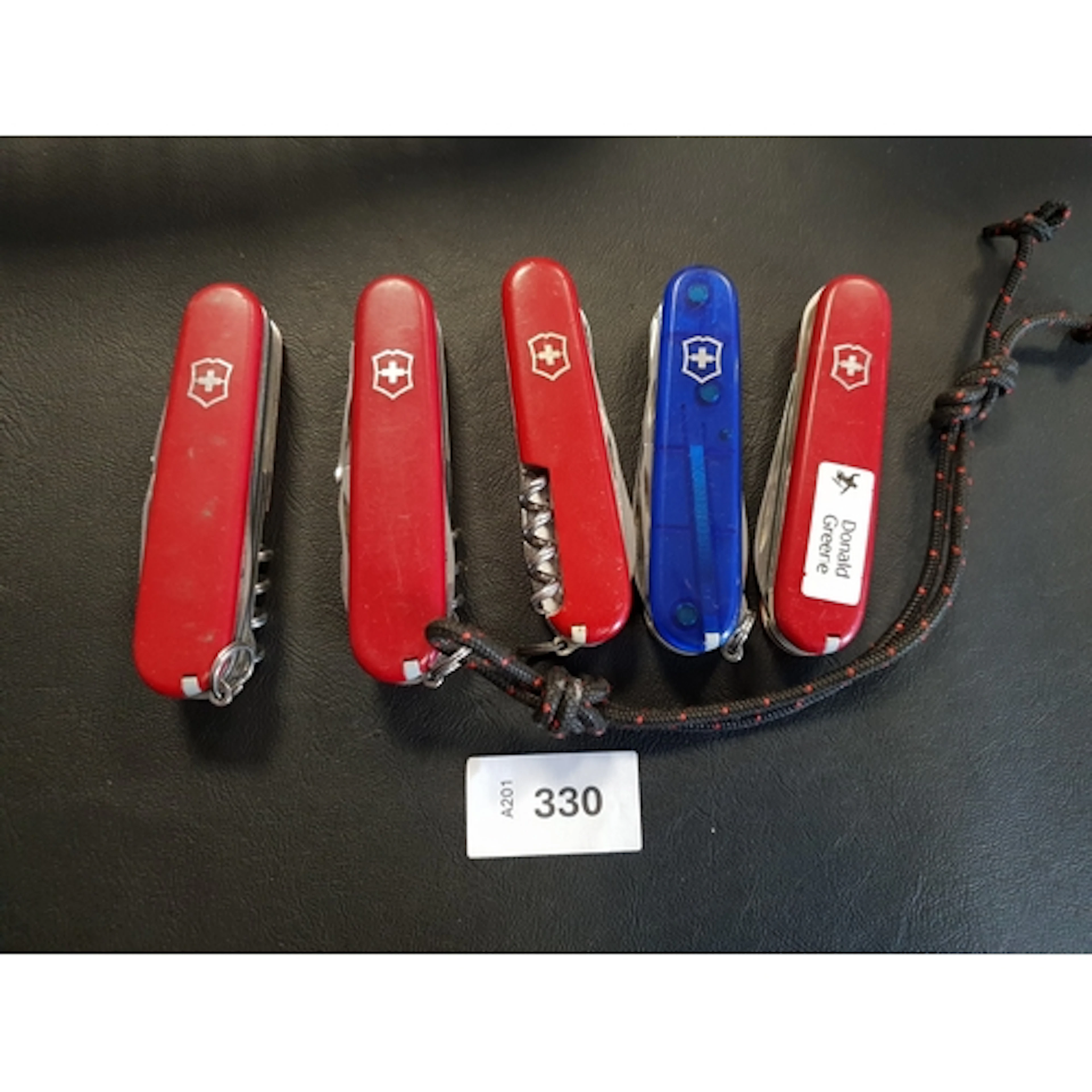 FIVE VICTORINOX SWISS ARMY KNIVES of various sizes and desig...