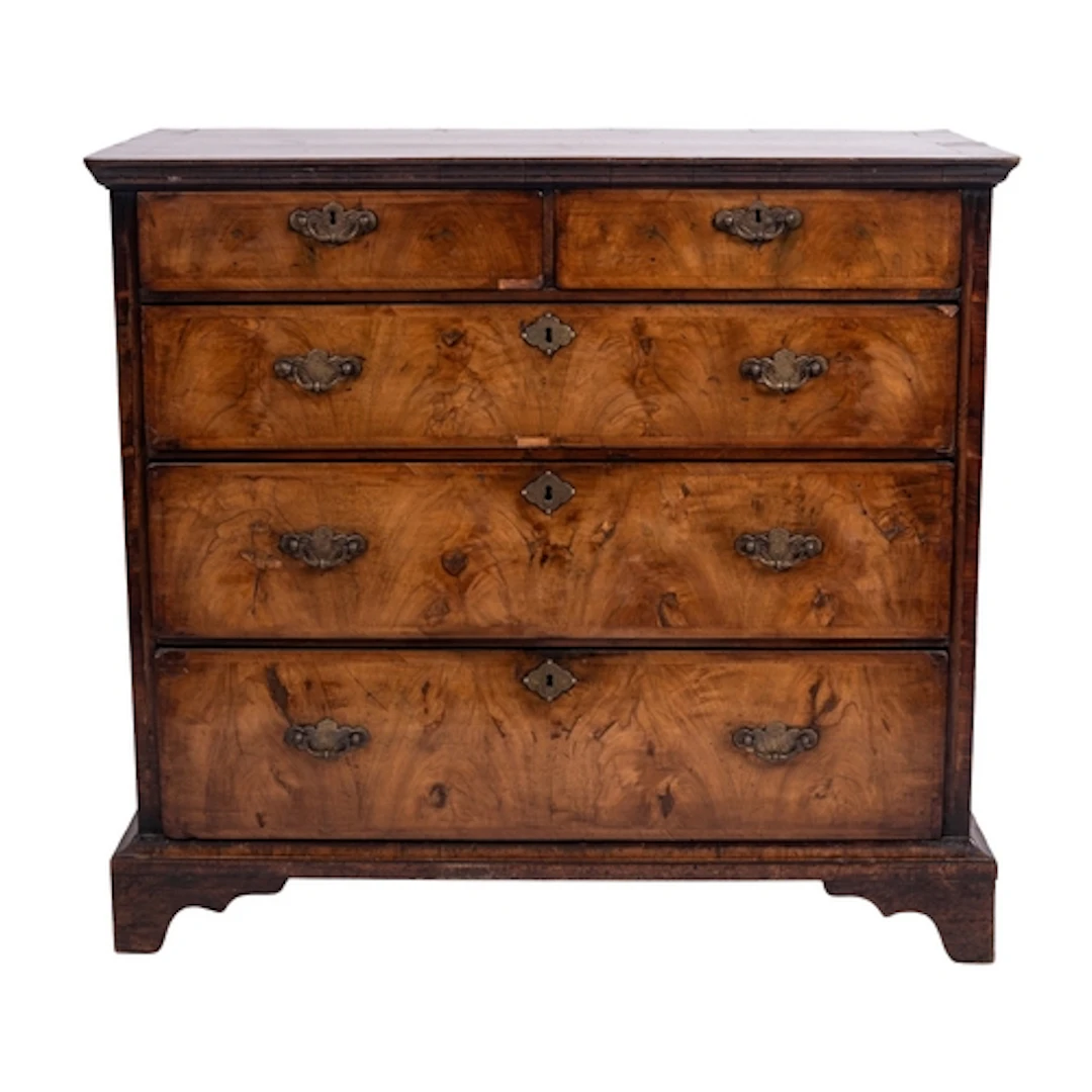 A George II walnut chest of drawers, circa 1735; the crossba...