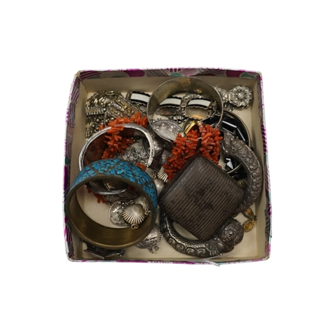 A group of silver and white metal jewels including makara ba...