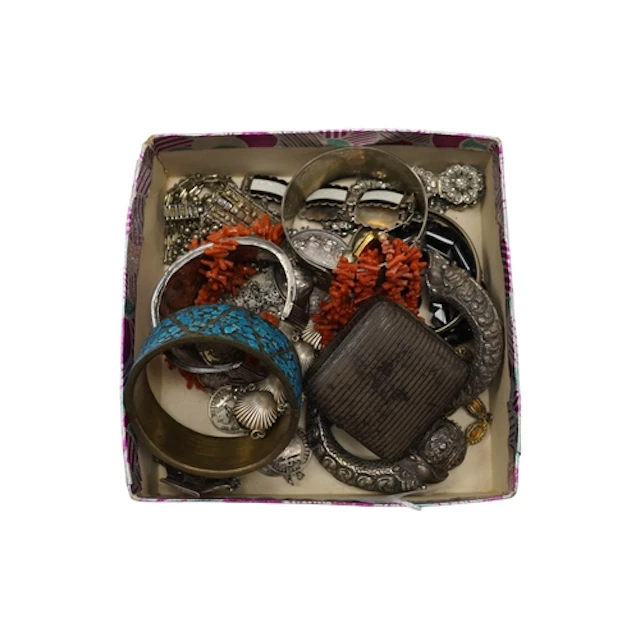 A group of silver and white metal jewels including makara ba...