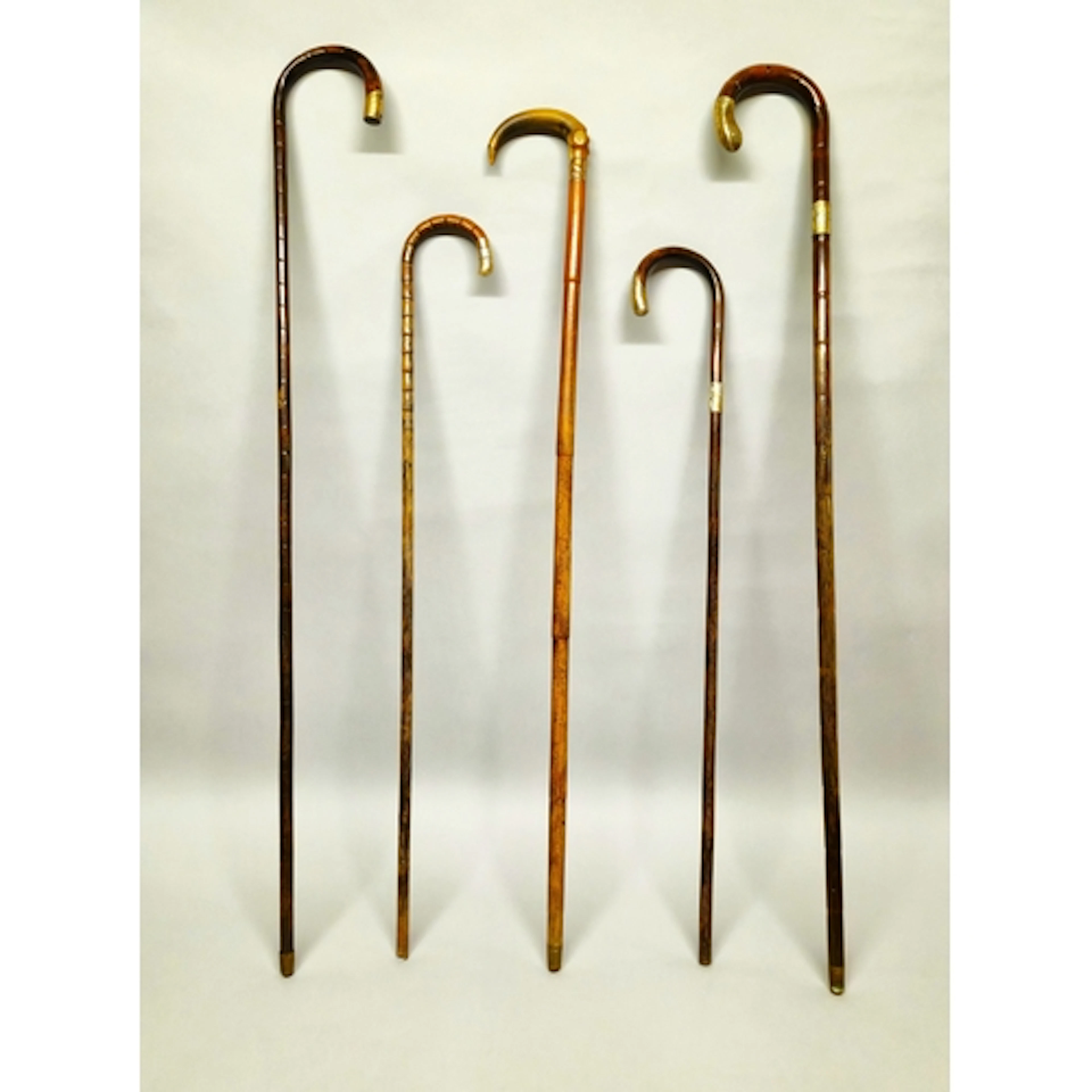 Group of five antique walking sticks with crook handles, sil...