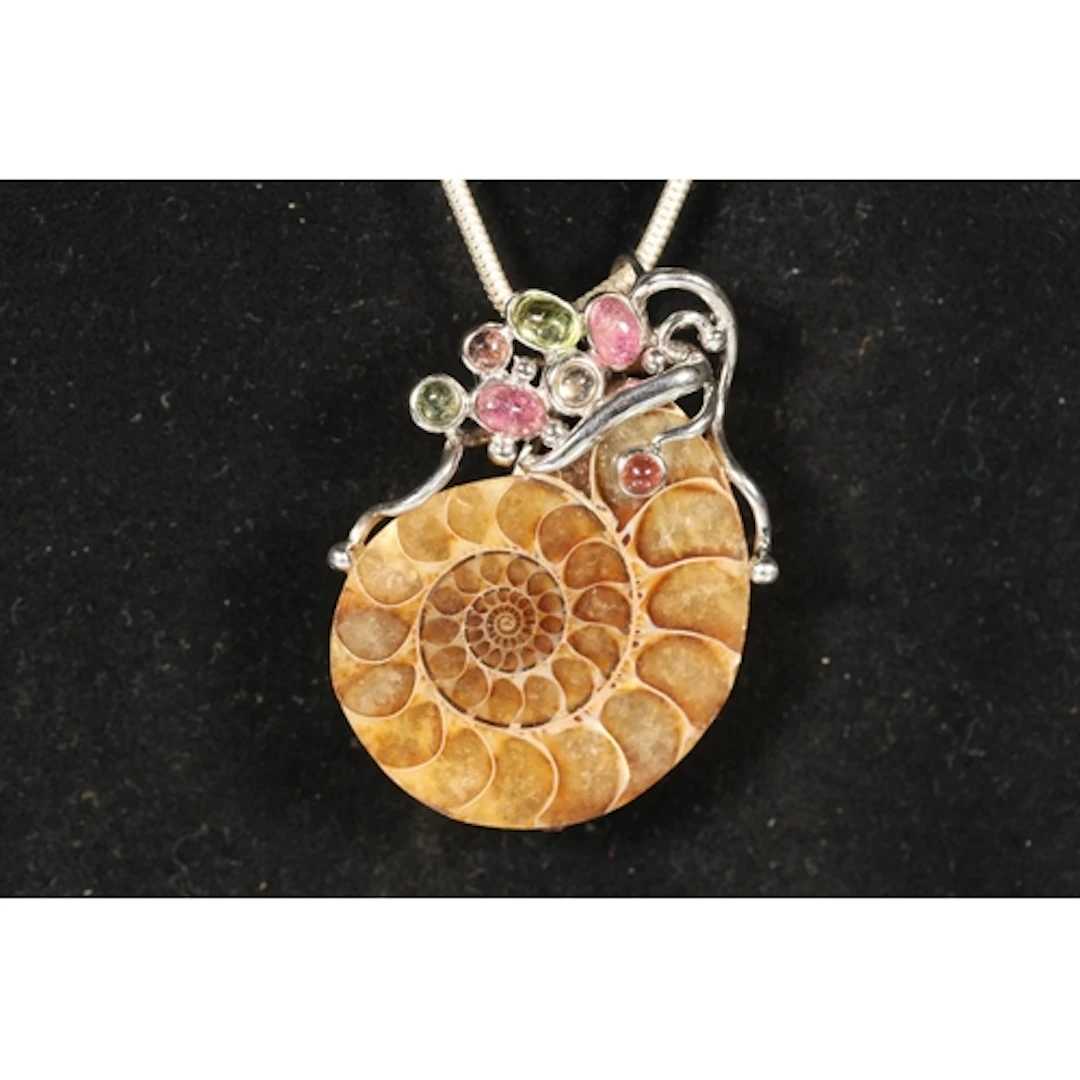 Silver mounted and gem set ammonite fossil pendant on silver...
