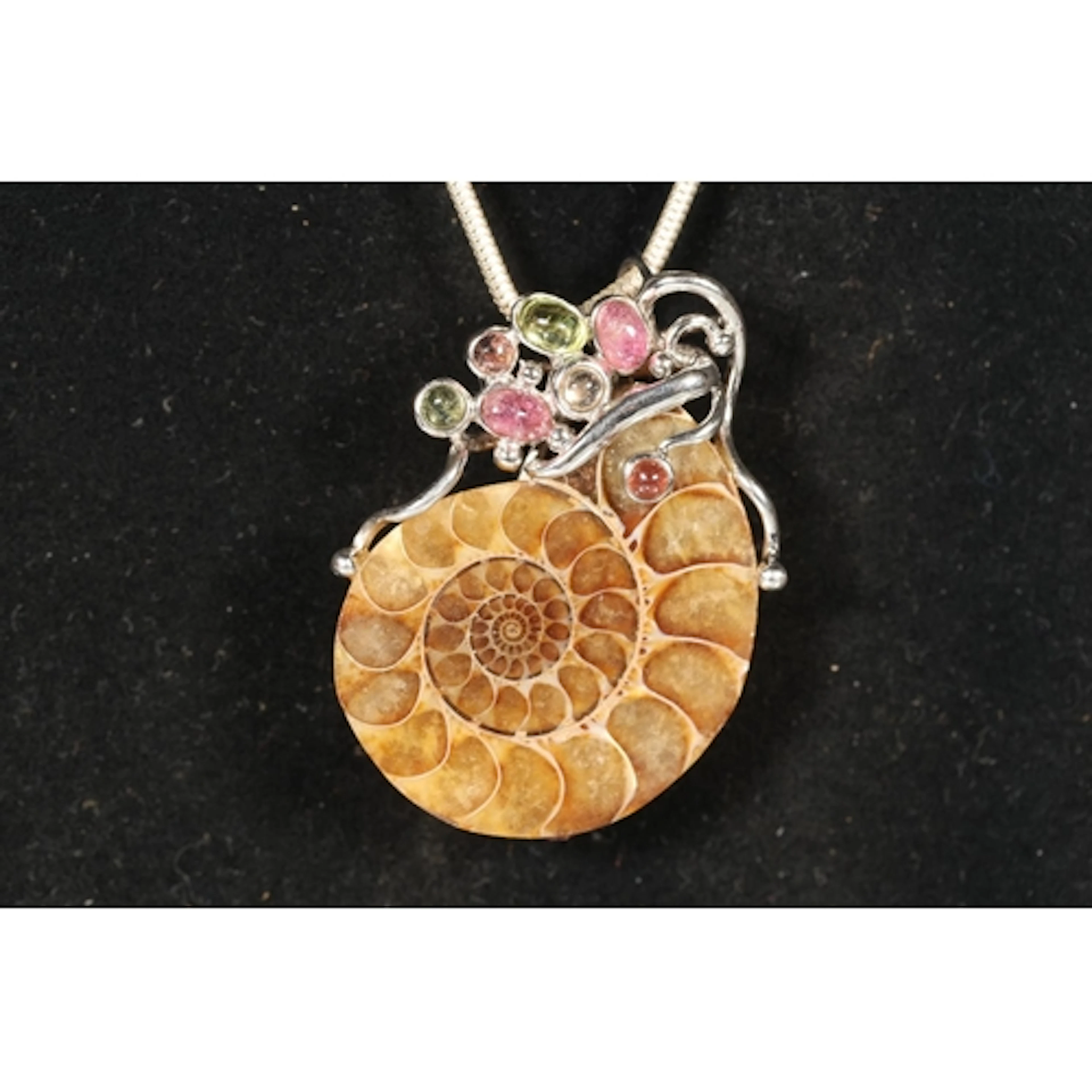 Silver mounted and gem set ammonite fossil pendant on silver...